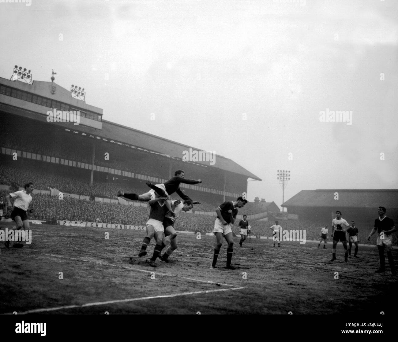 Manchester Utd goalkeeper Gregg flies over the heads of two players, one a Manchester United defender and the other the attacking Spurs player, Dunmore, during the division one match between Tottenham Hotspur and Manchester Utd at White Hart Lane. 7th February 1959. Stock Photo