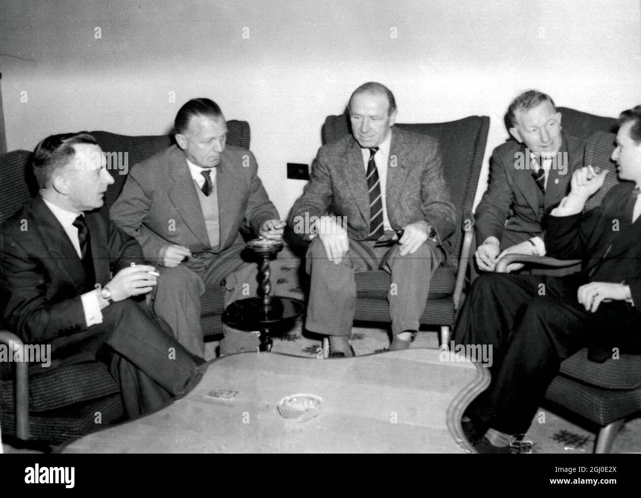 Officials of the Manchester United football team and of the Czechoslovak Army team, Dukla Prague sit around the table to arrange a new date for their cup tie match in the European Cup after the original match had been cancelled after the death of the president of Czechoslovakia. At the table are left to right: Mr W Crickmer, Manchester Utd secretary, Lt. Col.Bayer, president of the Dukla club, Matt Busby, Manager of Manchester Utd, Mr B.Whalley the Manchester Utd coach, and Mr V Peck an interpreter. Manchester - 13th November 1957. Stock Photo
