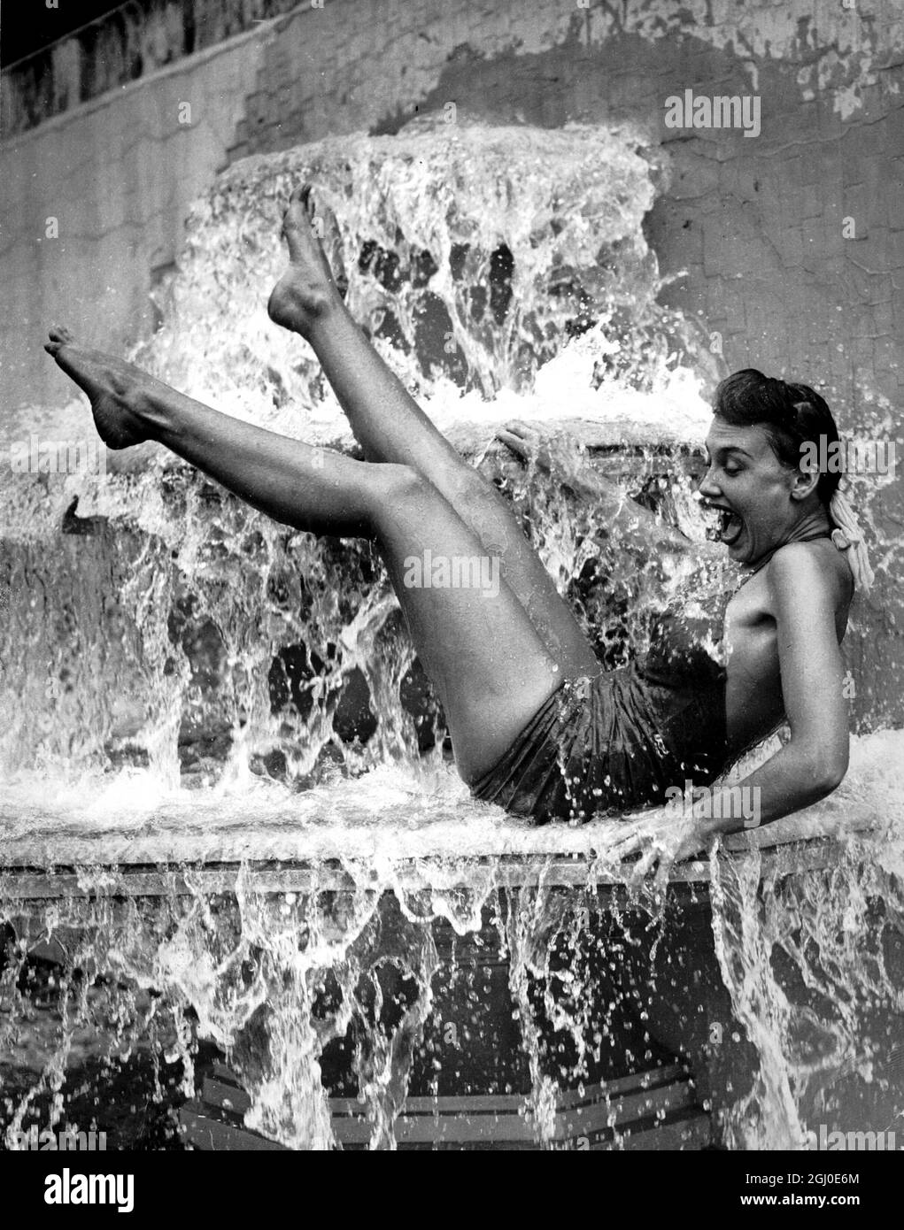 Cooler Than She Bargained For - 24th May 1952. With the advent of warm sunny weather, the search has once more begun for a place to keep cool, and one of the most popular, as usual, is the Open-air Swimming Pool at Roehampton. Diana Decker from Regent's Park, who will shortly appear in ''Arthur's Inn'', a new radio show with Arthur Askey, is photographed in a very effective position for keeping cool, in fact, a little too cool, it seems. Stock Photo