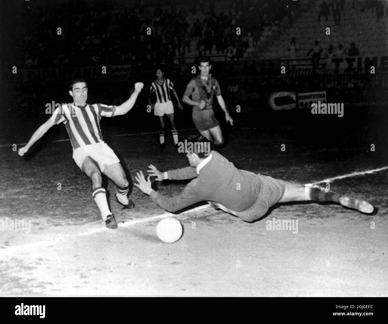Sideris of Olympiacos (Athens) is pictured materializing the first and unique Greek goal in the eighty-second minute of the second half during the Olympiacos versus Barcelona. Pesudo, the Spanish goal-keeper's interference did not save the situation. The game was played in conjuction with the Grecian-Spanish festivities on the occasion of the Royal wedding which linked the two countries. The result : Olympicaos 1 Barcelona 0 May 22nd 1962 Stock Photo