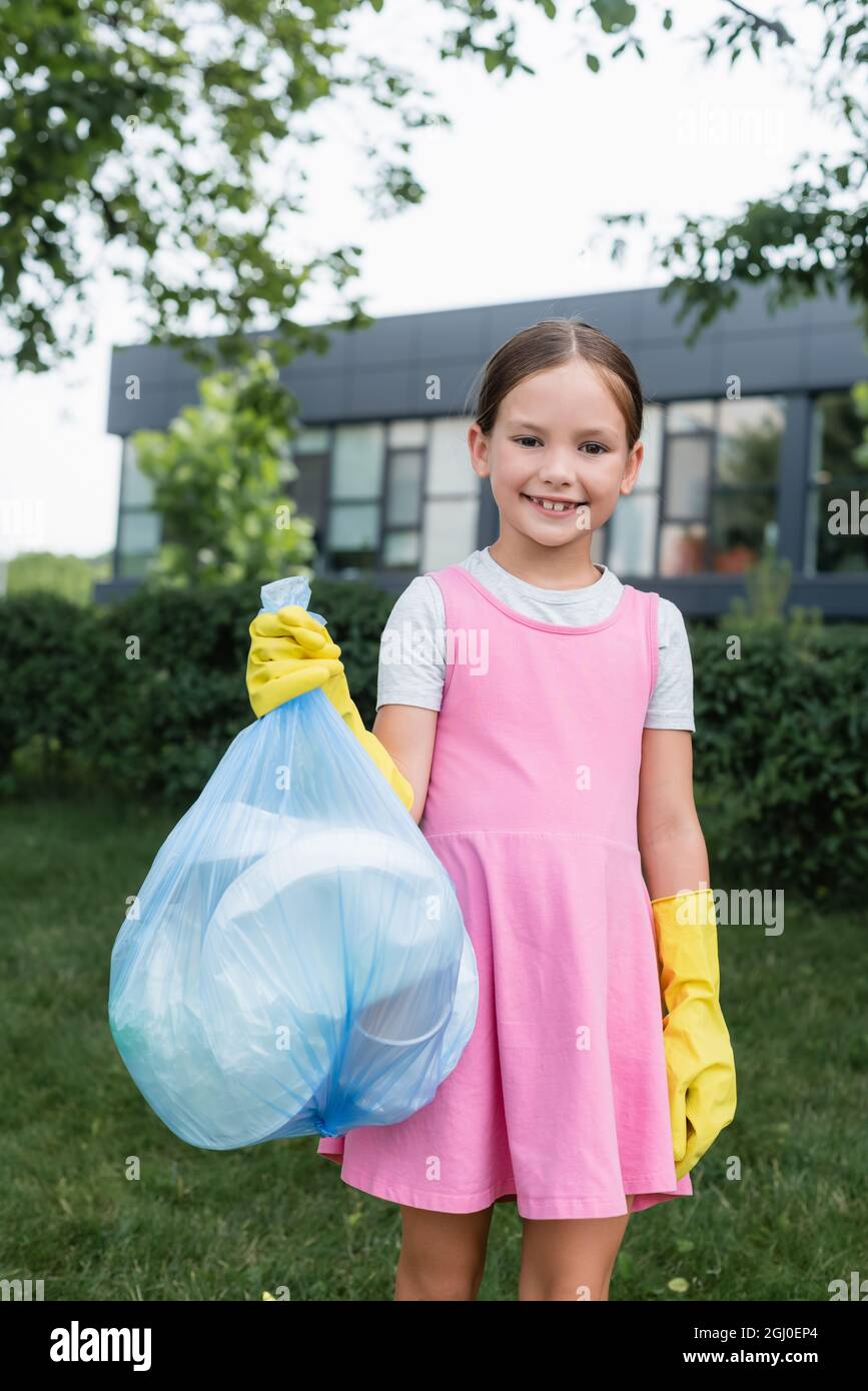 Smiling child holding trash bag outdoors Stock Photo Alamy