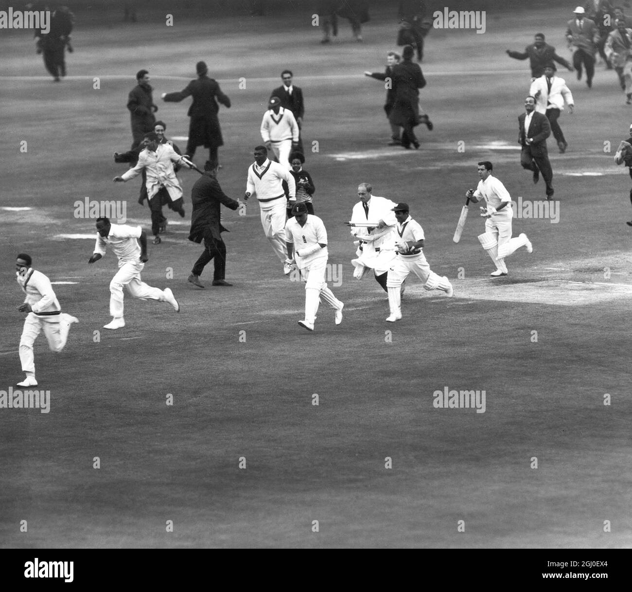 England v West Indies Crowds of West Indies supporters sworm onto the pitch at Lords to congratulate their team. In the centre with bandages around his arm is Colin Cowdrey, who came on in a last hope to win. 25th June 1963 Stock Photo