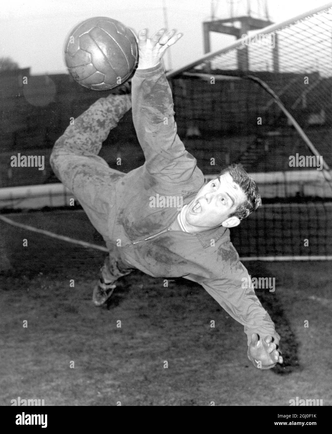 Nineteen year old Chelsea goalkeeper John Dunn, one of Chelsea's two young goalkeepers makes an acrobatic save during training at Stamford Bridge. Dunn is set to make his FA Cup debut against Tottenham Hotspur at White Hart Lane on Saturday because Peter Bonetti has a fractured finger. 31st December 1963. Stock Photo
