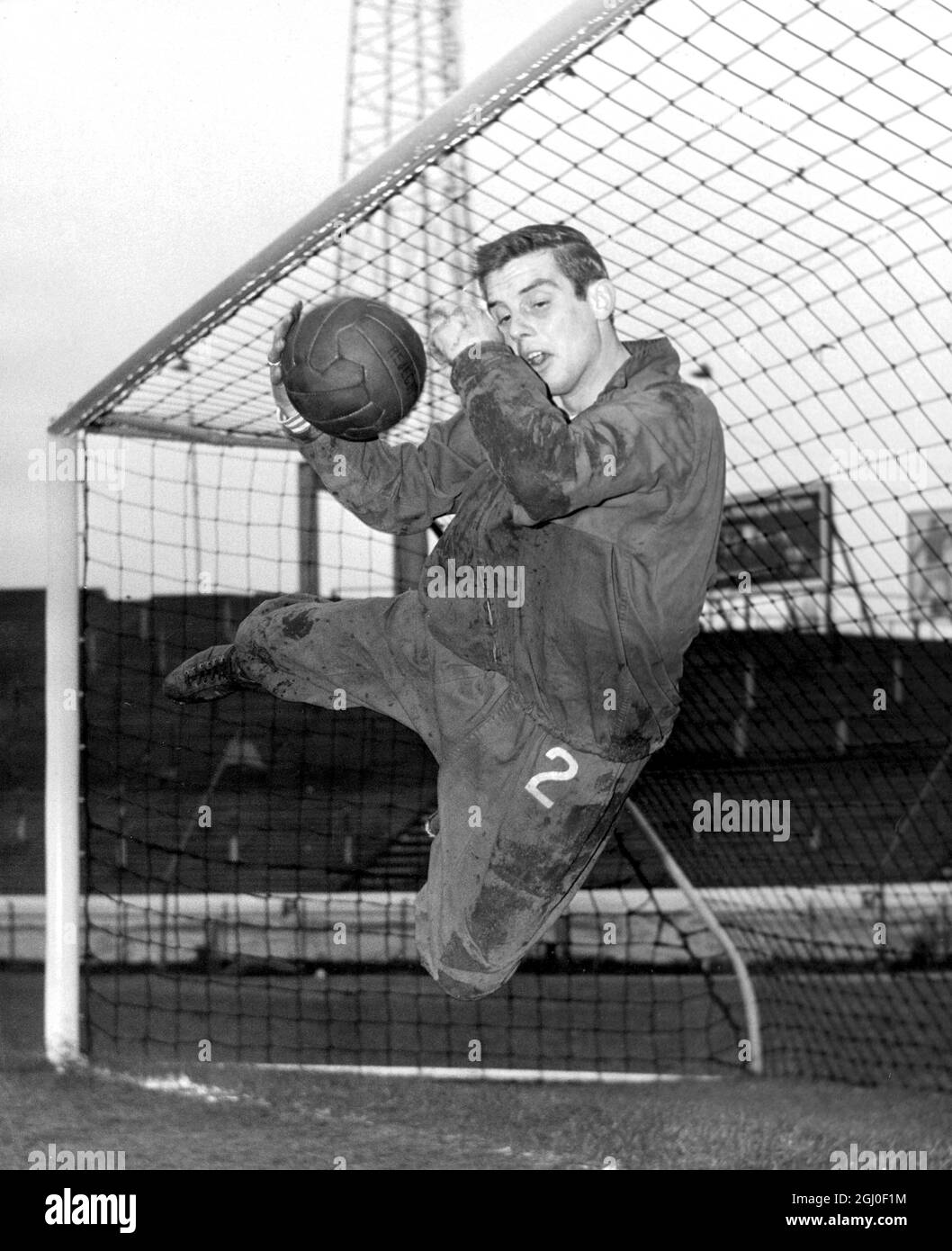 Nineteen year old Chelsea goalkeeper John Dunn, one of Chelsea's two young goalkeepers makes an acrobatic save during training at Stamford Bridge. Dunn is set to make his FA Cup debut against Tottenham Hotspur at White Hart Lane on Saturday because Peter Bonetti has a fractured finger. 31st December 1963. Stock Photo