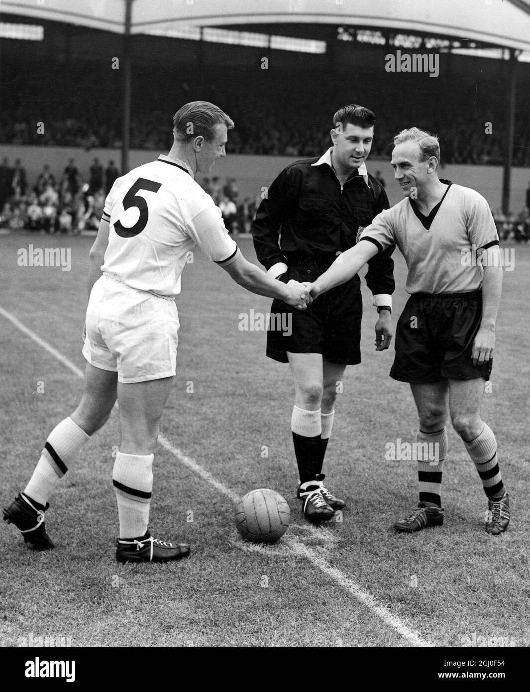 Billy Wright, England and Wolverhampton Wanderers centre half and captain made his final appearance when he captained the first team v the reserves in a public practice match at Molineux before a crowd of £20,000. Billy Wright shakes hands with his sucessor George Showell, the centre half and captain of the reserve team. 9th August 1959. Stock Photo