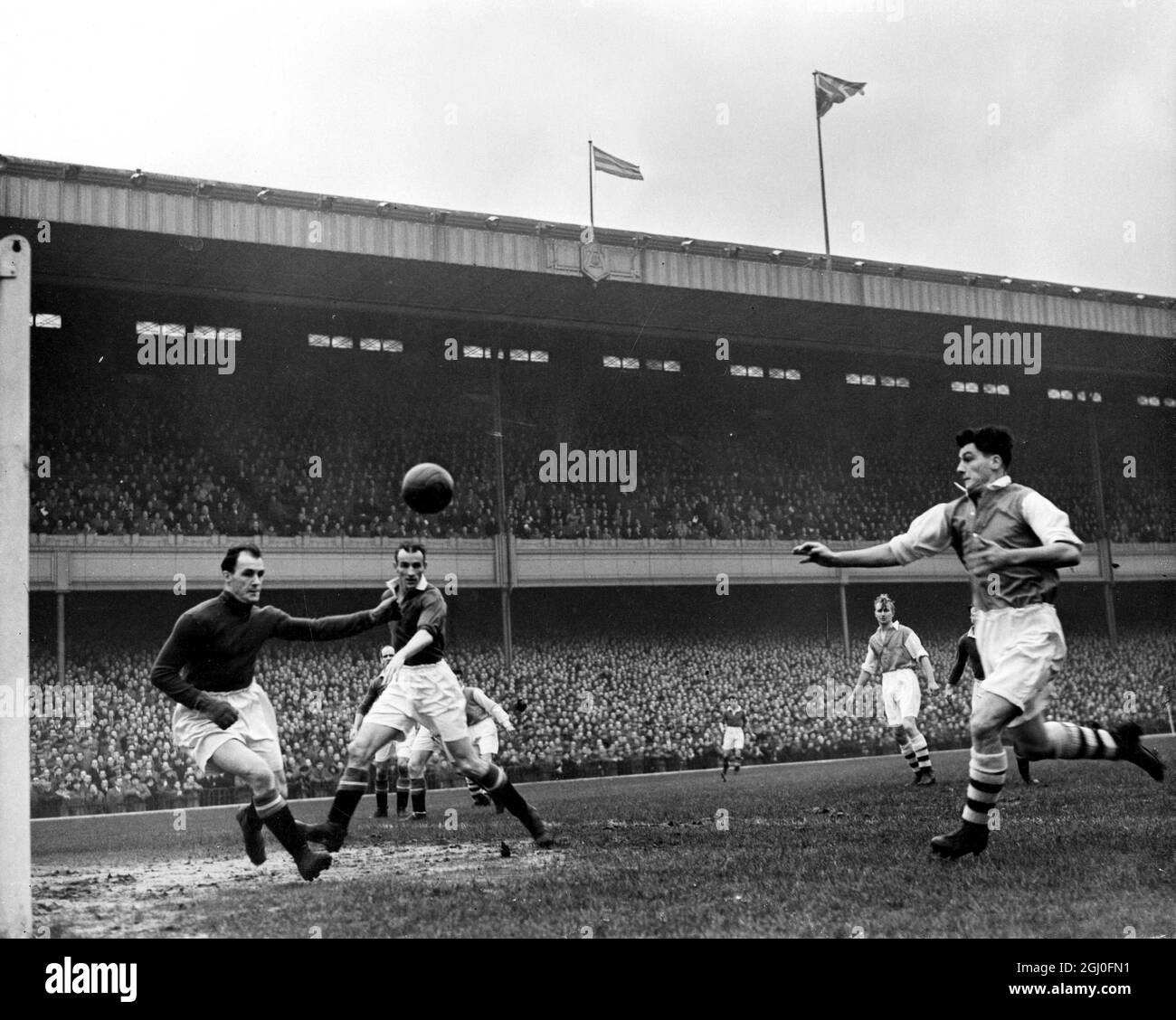 Arsenal v Manchester United Cliff Holton, the Arsenal centre forward (on right) follows up his header, which is cleared by Jack Crompton (Manchester United goalkeeper) while Chilton, the Manchester United centre half is seen in close attendance. 8th December 1951. Stock Photo