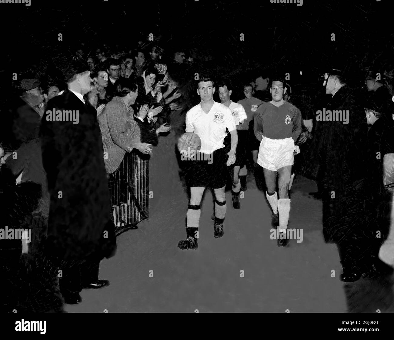 London Select 11 v Barcelona Coming out of the tunnel onto the field at Stamford Bridge Johnny Haynes England and Fulham player holds the ball as he leads the London team. Leading the Barcelona team is Ribelles. 5th March 1958 Stock Photo