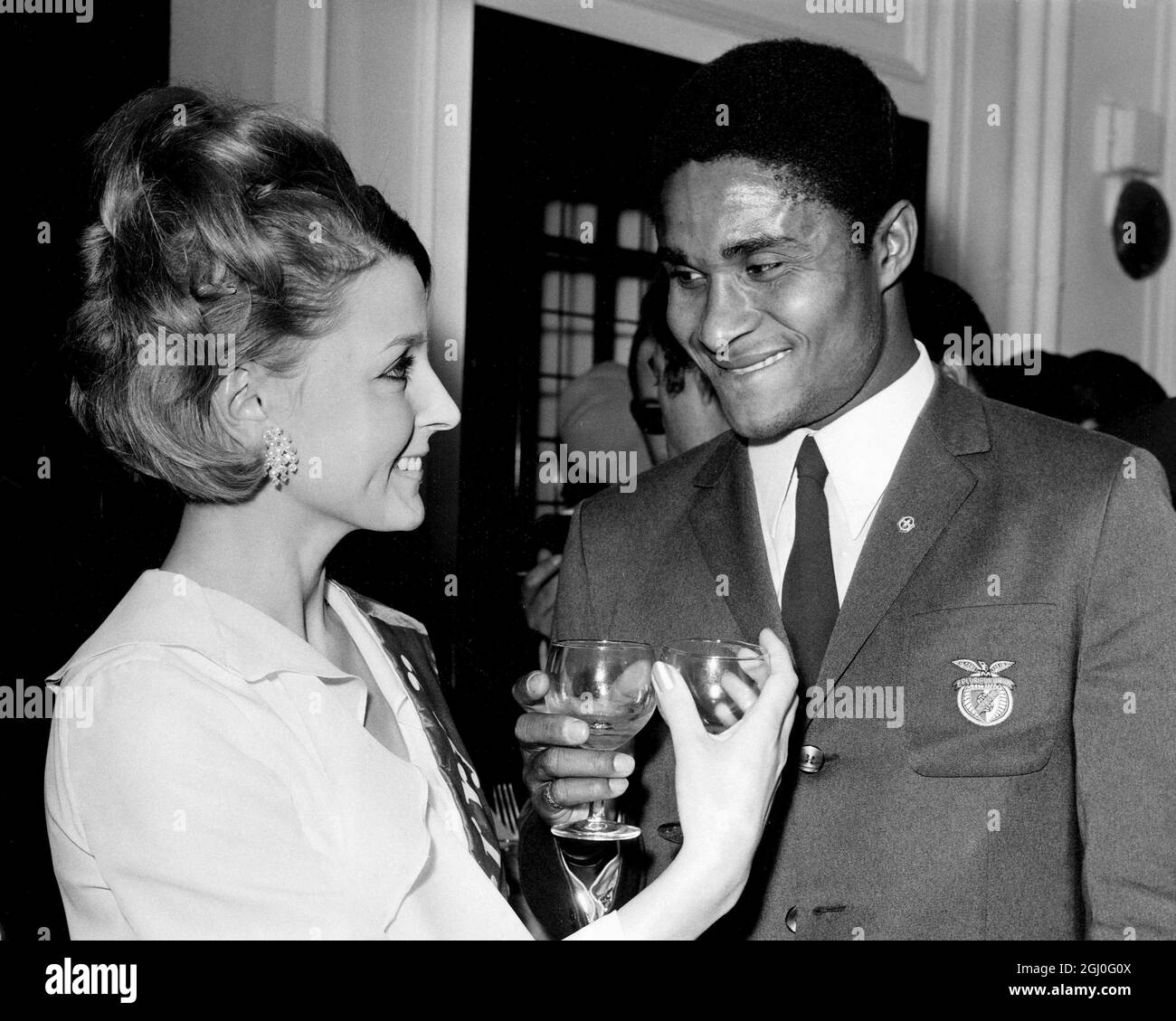 Eusebio (right) Benfica's star player, takes a consolation drink after his  team was defeated 4-1 by Manchester United in the European Cup Final. Photo  shows Eusebio with Patricia Neane of Stockwell, who