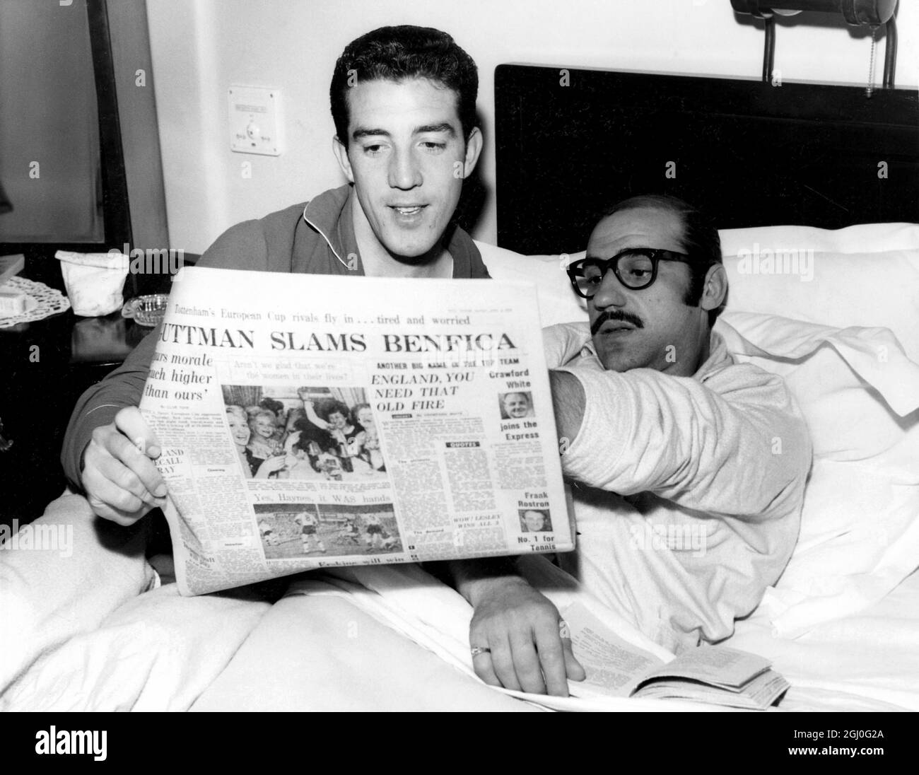 Benfica centre-half, Germano (right), reads an account of the Spurs v Manchester United match prior to their game with Spurs in the semi-final of the European Cup. 2nd April 1962 Stock Photo
