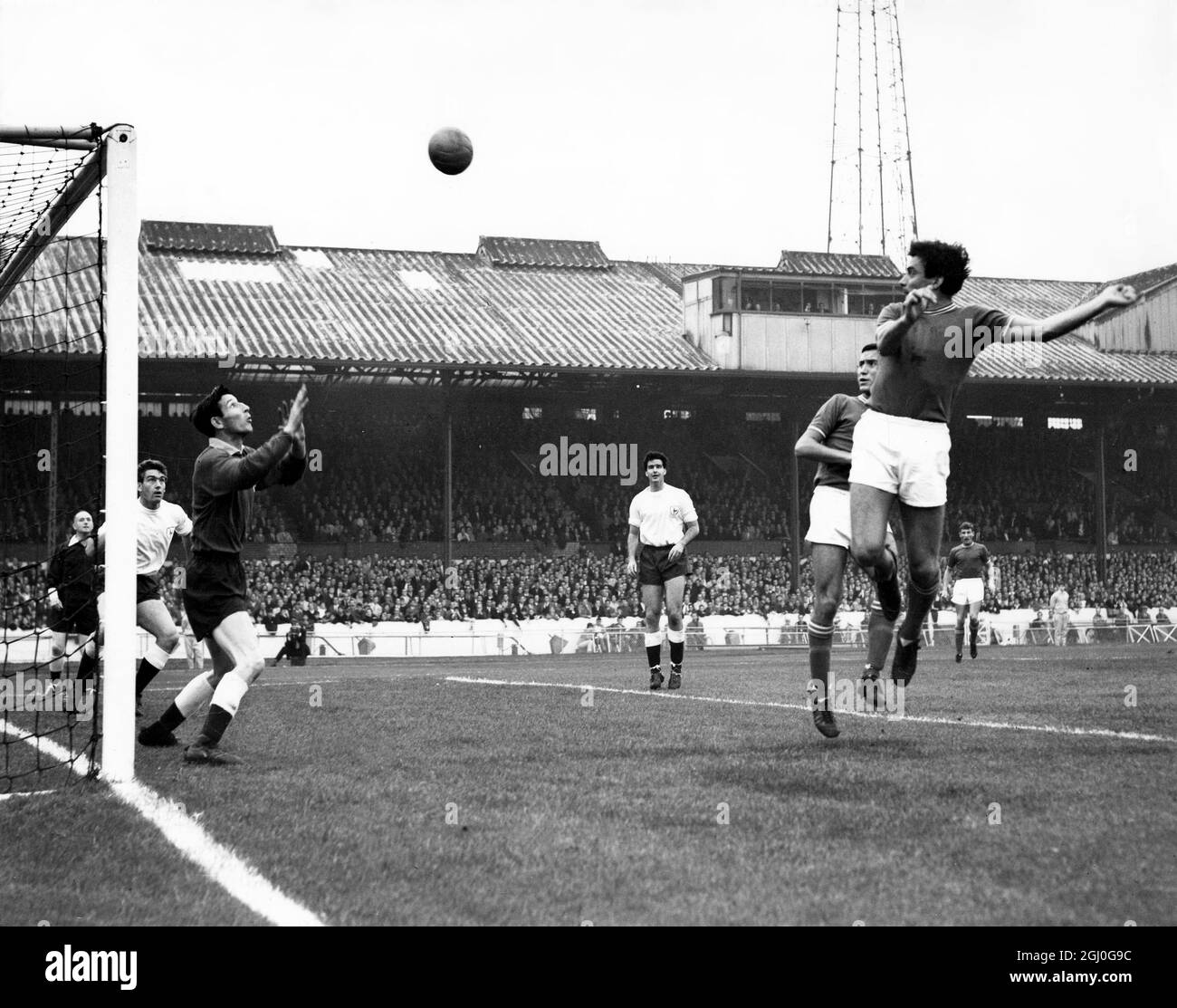 Chelsea v Tottenham Hotspur Tambling, the Chelsea inside-right, heads the ball over Brown, the Spurs' goalkeeper and over the bar for a goal kick during the match at Stamford Bridge. 21st September 1963 Stock Photo