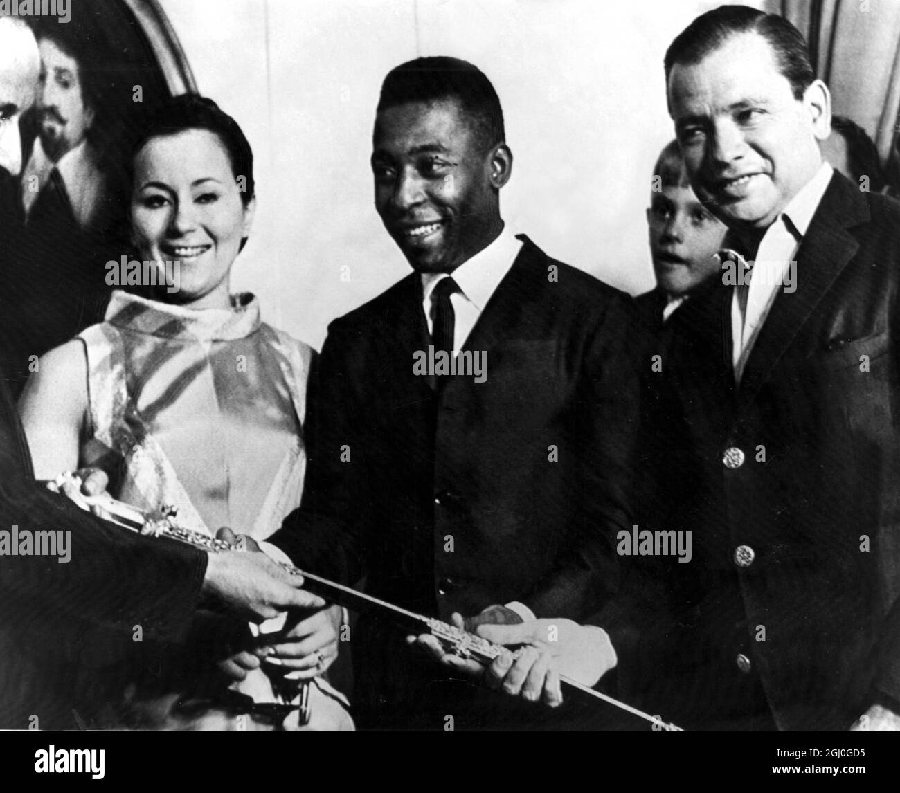 Pele receiving another award, the Gold Sword, presented by the British Year Sports Book. Ernest Hecht (left), awards the International Football Year Book to Pele. Pele's wife, Rosemaire Nascimento is second left and Sao Paolo governor, Roberto De Abreu is on the right. 21st February 1968 Stock Photo
