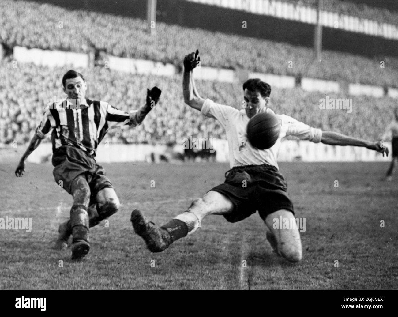 FA Cup 4th Round Tottenham Hotspur v Newcastle Utd Clark (right), Spurs centre-half, chests the ball away from a centre by Walker (left), Newcastle's outside-right. 2nd February 1952 Stock Photo