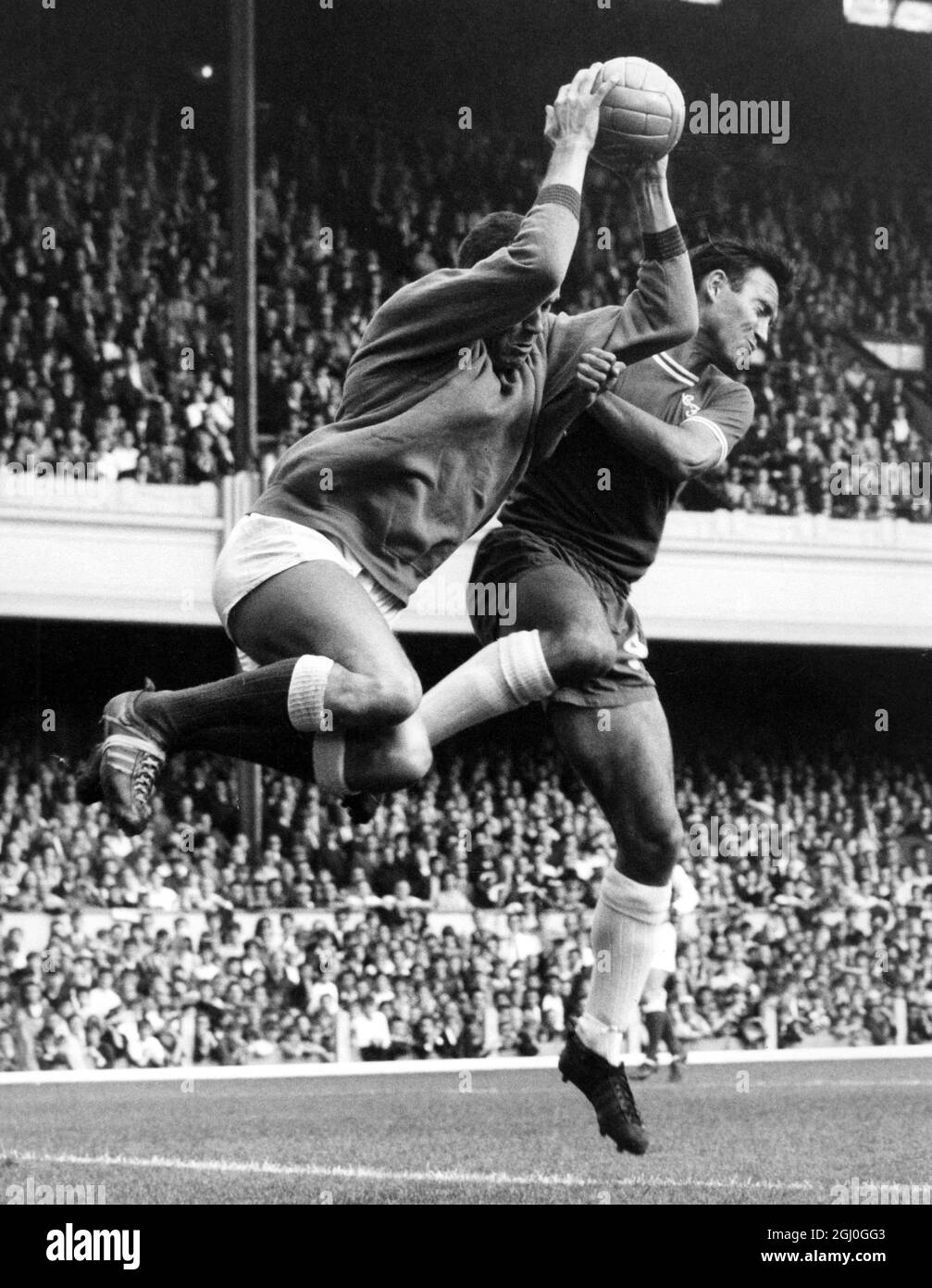 Arsenal v Chelsea Arsenal goalkeeper, Jim Furnell leaps to snatch the ball away from the Chelsea centre-forward, Barry Bridges' head to halt another Chelsea attack during the London derby at Highbury. 26th September 1964 Stock Photo