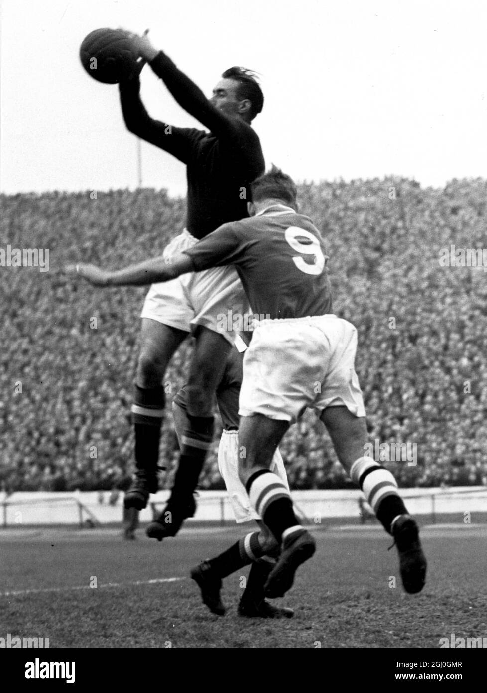 Chelsea v Manchester United A brilliant save by Manchester United goalkeeper, Wood, when under heavy attacking pressure from Chelsea forward, Roy Bentley. Manchester's centre-half, Chilton, the captain, anxiously assists Wood to clear during the match at Stamford Bridge. 16th October 1954 Stock Photo