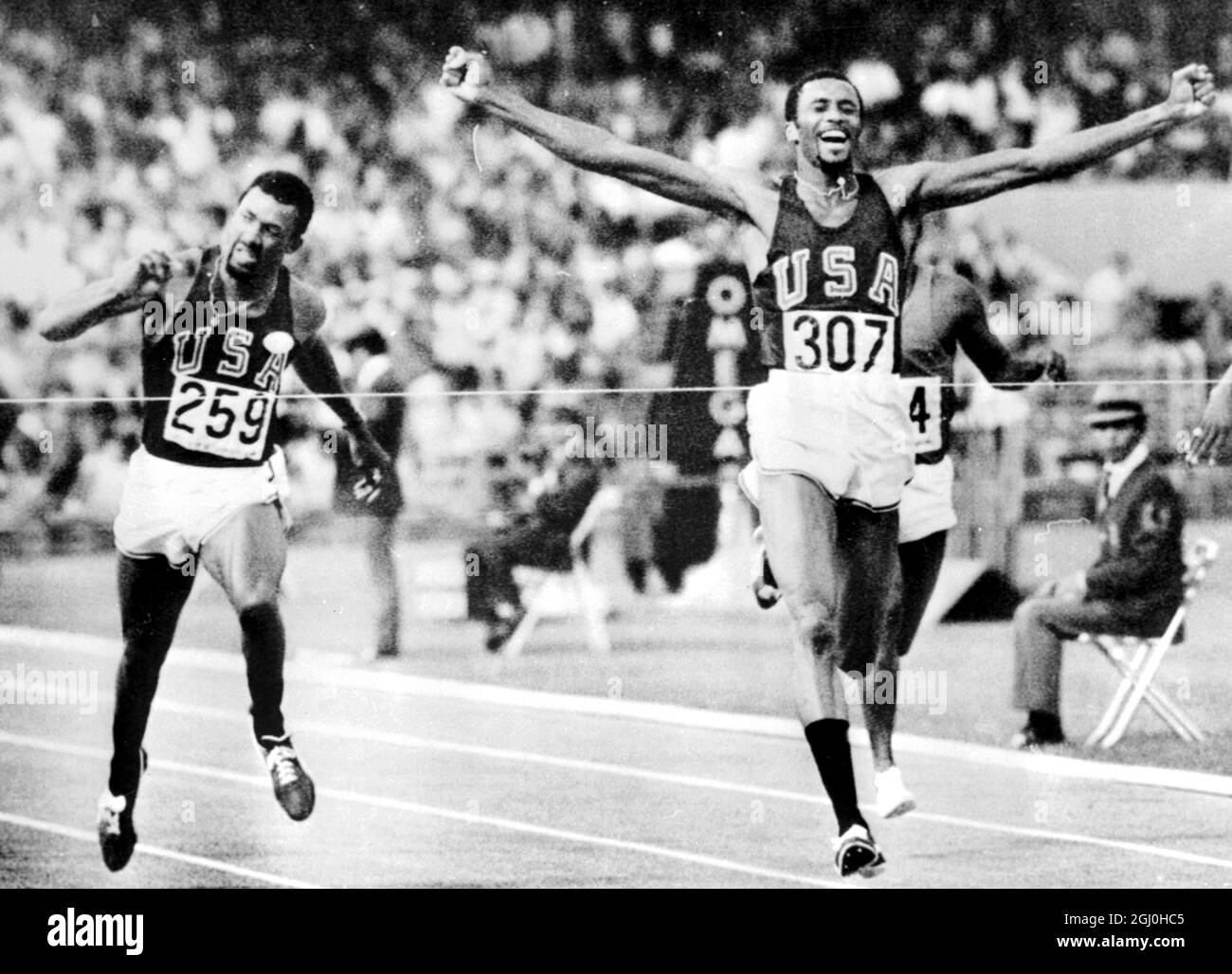 Mexico City: Tommie Smith, of Lemoore, Calif., Throws his arms up in victory as he its the tape to win a Gold Medal in the Men's 200 - meters final at the 19th Olympic Games her yesterday. his time of 19.8 seconds set a new world record. Running despite an injured leg muscle, he streaked past team mate John Carlos, of San Jose, Calif., (left), who was placed third behind Australia's Peter Norman, who won the Silver Medal 17 October 1968 Stock Photo