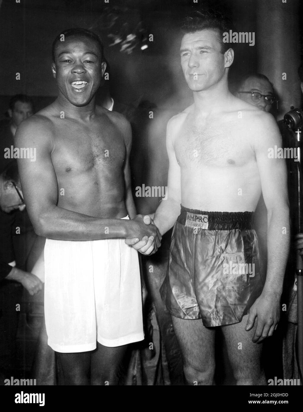 Peter Waterman, the undefeated London welterweight (right) shakes hands  with ""The Cuban Hawk"", Kid Gavilan, former World Welterweight champion  after their weigh-in at Jack Solomon's gym. They meet in an international  contest