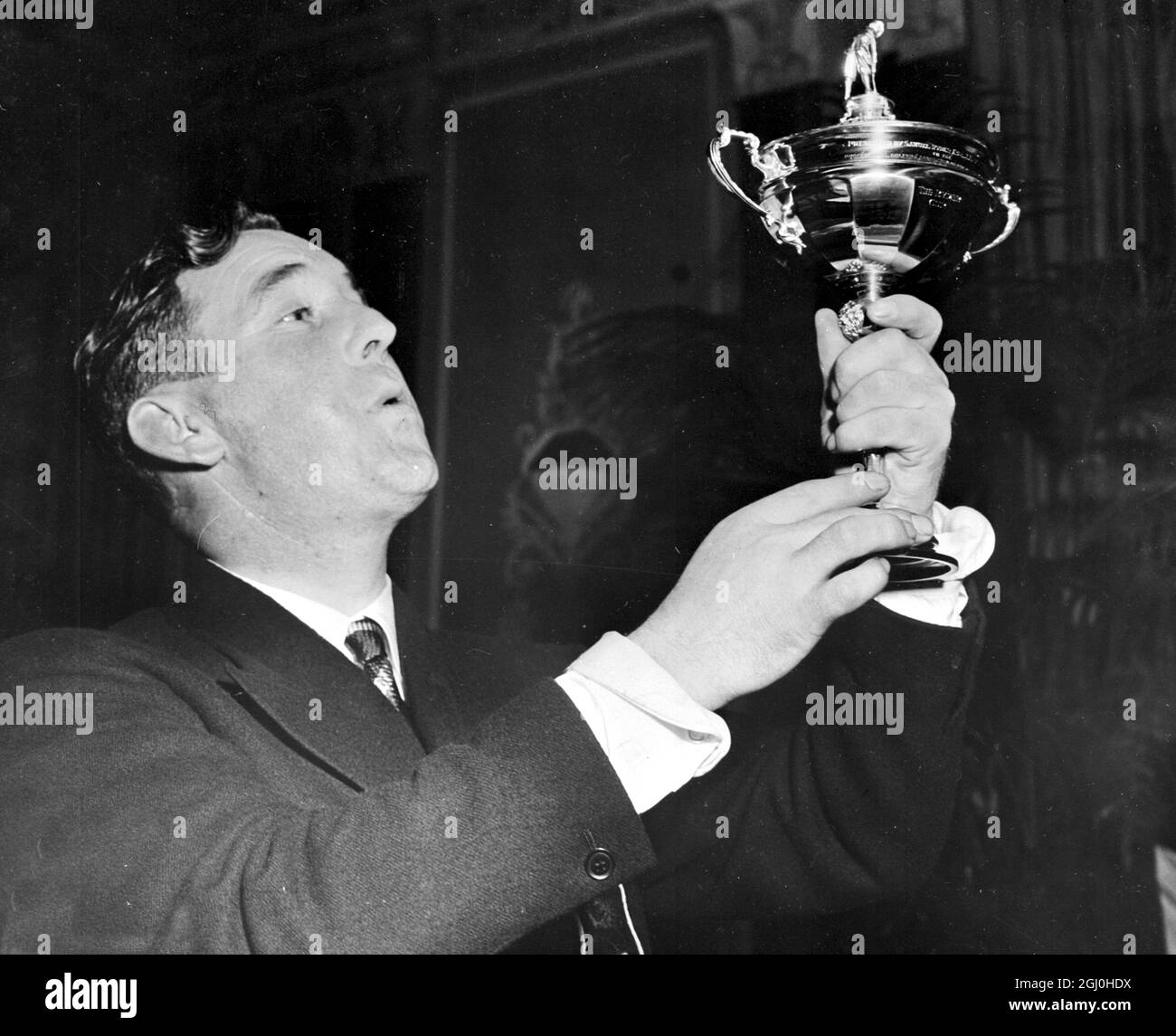 Fred Daly, British Open Golf Champion and Members of the British Ryder Cup Team, admiringly ''eyes'' the cavorted Ryder Cup at the dinner given in honor of the visiting British Team by Robert A. Hudson, member of the Tournament Advisory Board, P.G.A. at the Waldorf Astoria, New York. The British team will play against the American Ryder Cup Team at Portland Oregon, on November 1st and 2nd for Ryder Cup Championship. 26 October 1947 Stock Photo