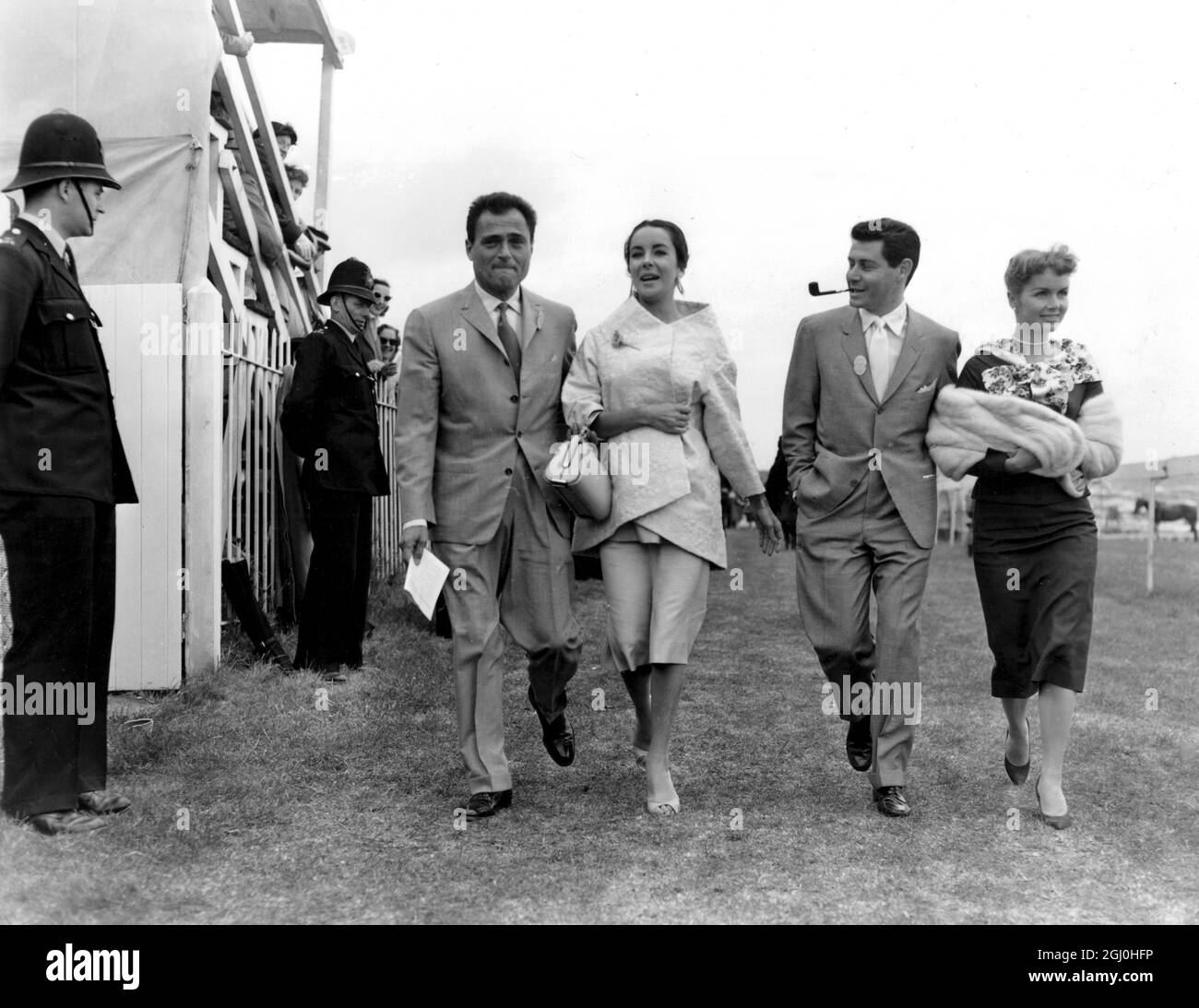 Epsom Derby Walking down the course before the big race are American singer Eddie Fisher and his wife Debbie Reynolds and Elizabeth Taylor and her husband Mike Todd June 1957 Stock Photo