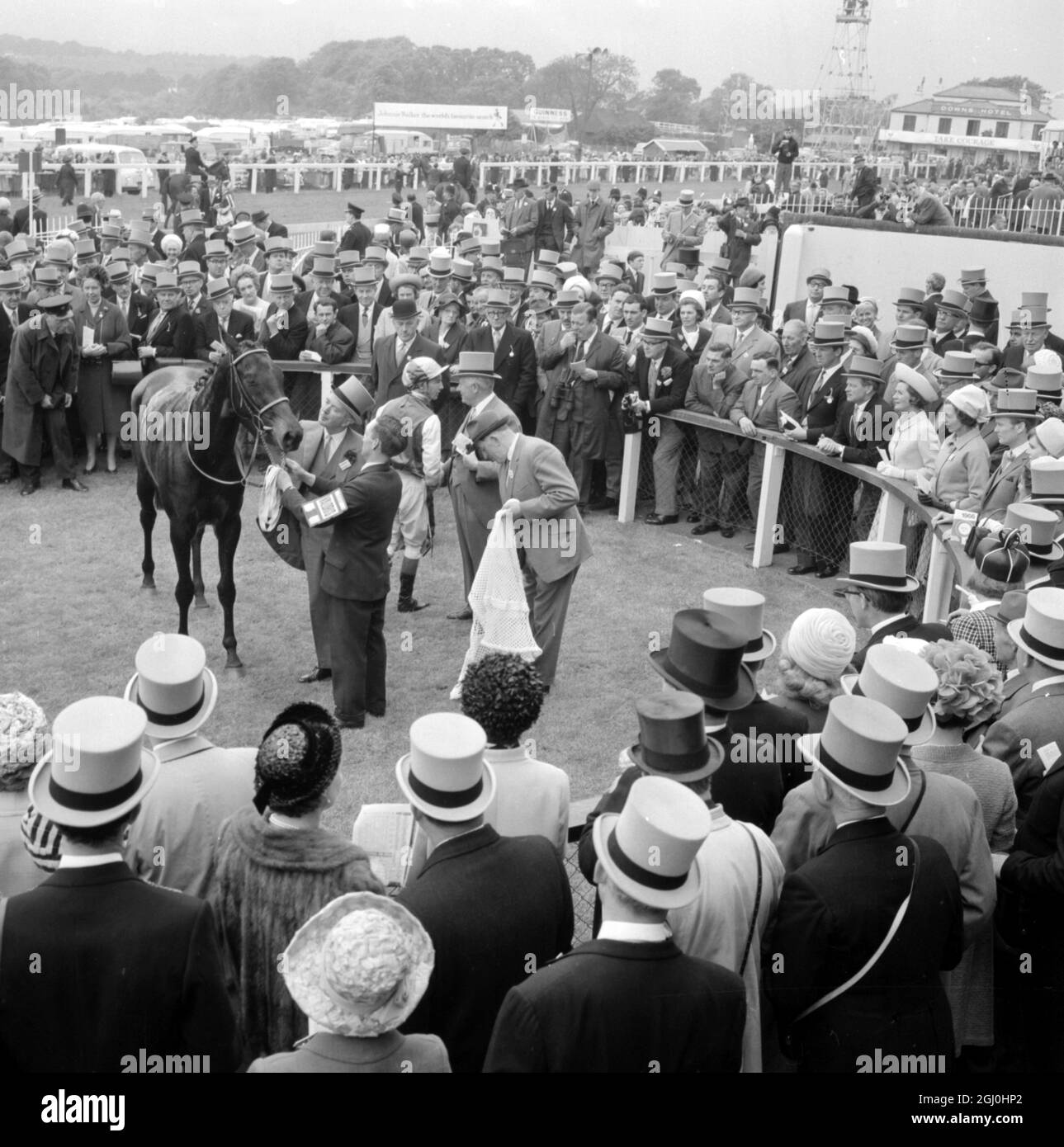 Epsom, surrey, England : financier Mr. Charles Clore ( topper, profile, right ) Congressional jockey, Lester Piggott at Epsom today, aften he won the Oaks Stakes up on Mr. Clore’s course, Valoris ( left ), being patted by Irish trainer, top hatted, Vincent O’Brien. Valoris finished two and a half lengths in front of the 6 to 1 shot Berkeley Springs, owned by American banker, Paul Mellon, with Geoff Lewis in the saddle . Third, three lengths further away came Wickham-Boynton’s Varinia, an unconsidered outsider ridden by Stan Clayton at the odds of 100 to 7. The race was a consolation for O’Brie Stock Photo