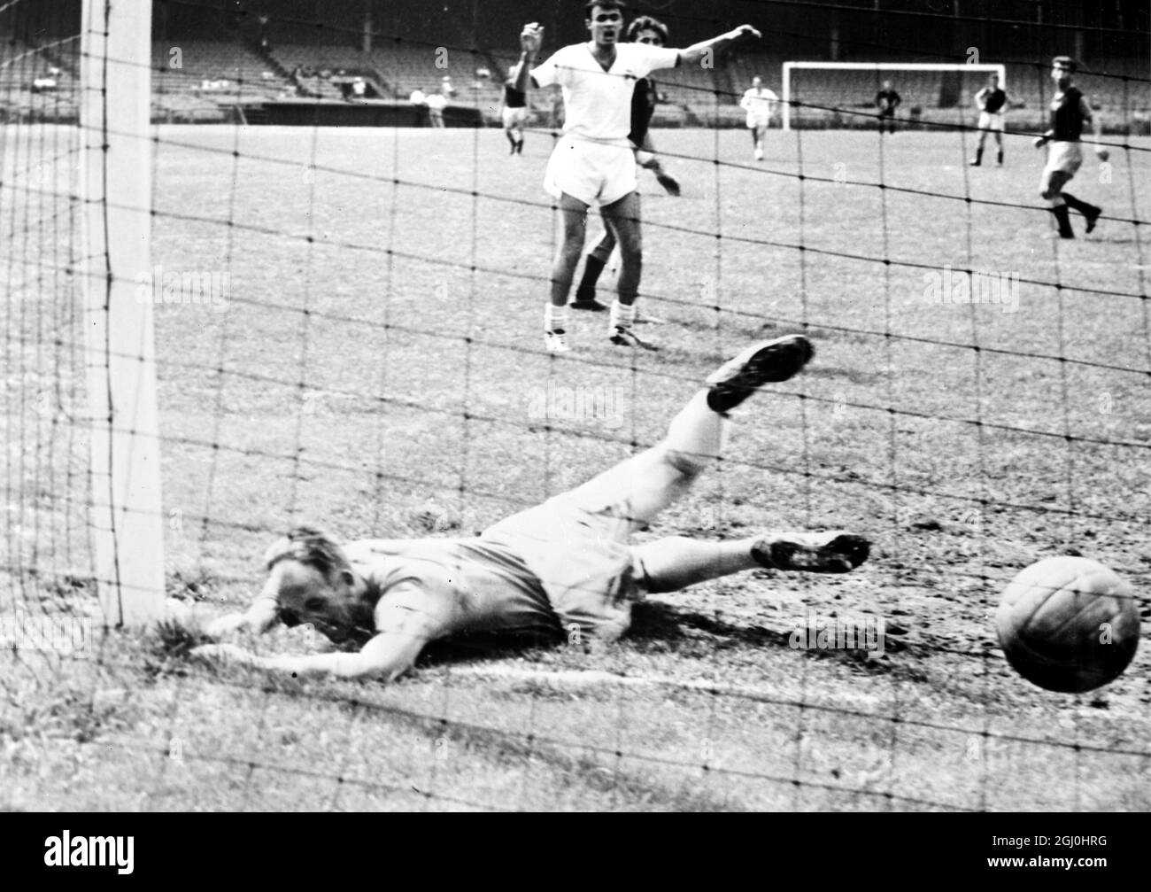 New York: Ireland's Shamrock Rover goalkeeper Eamon Darcy sprawls in the dirt after failing to stop a goal by Czechoslovakia's Dukla team during the International Soccer League game here July 30th. Dukla, the second-section champions established a single game high, and Rydu Kucera set an individual a single game high, and Rydu Kucera set an individual record with five goals as the Czechs routed the Rovers of Dublin 10 goals to nil. 1 August 1961 Stock Photo