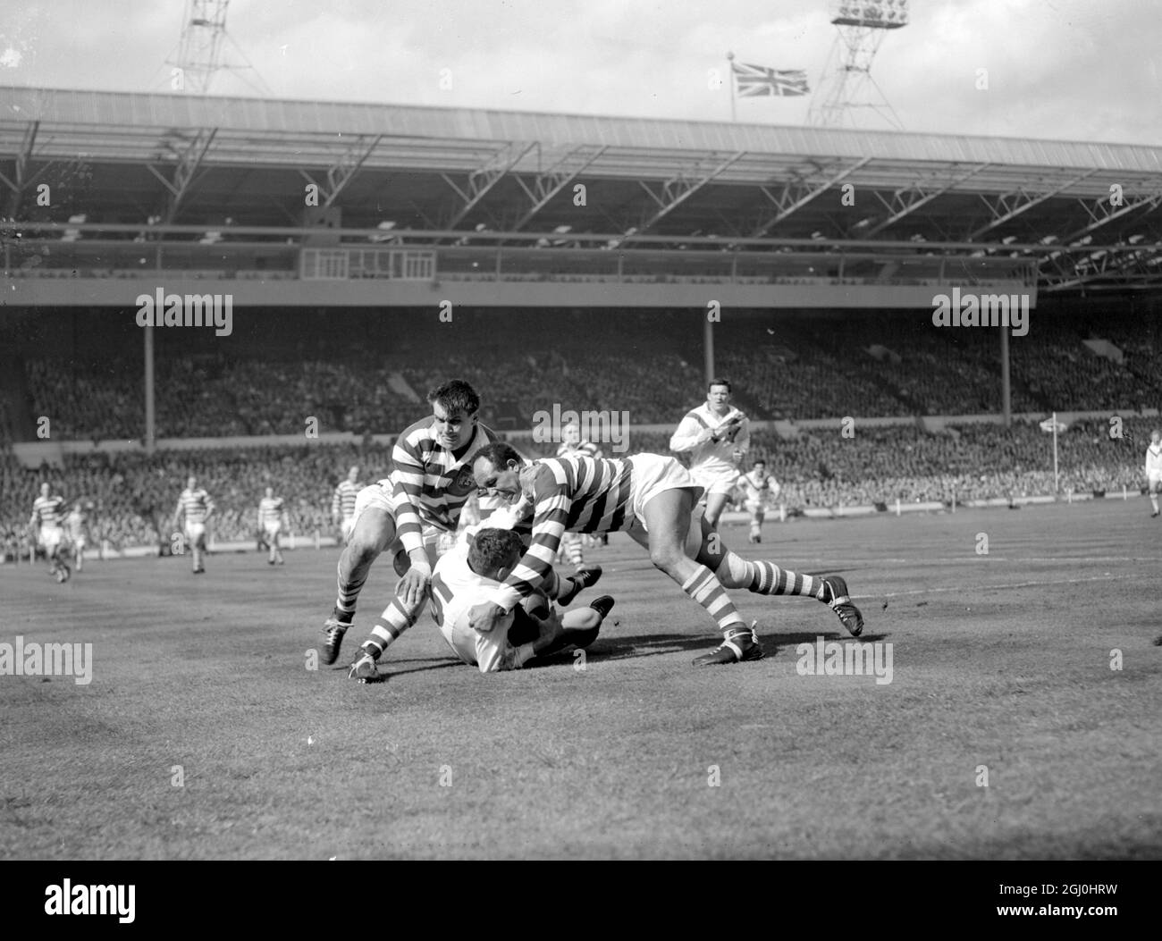 London: Coetzer of Wakefield (on ground) tries to fight off Wigan's Billy Boston (right) as he is tackled during today, Rugby League Cup Final between the two teams at Wembley Stadium, London. Wakefield won the Cup by beating Wigan 25-10 11 May 1963 Stock Photo