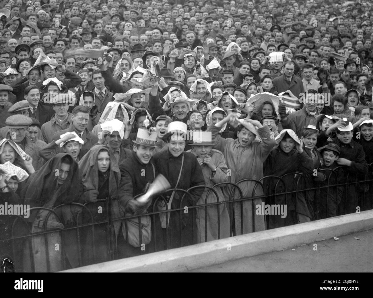 Enormous crowds flocked to Highbury today to watch the 1st Round Cup battle between Arsenal and Tottenham Hotspurs, the first time these two teams have met in a Cup game Arsenal supporters improvise umbrellas as they wait the start of game. 8 January 1949 Stock Photo