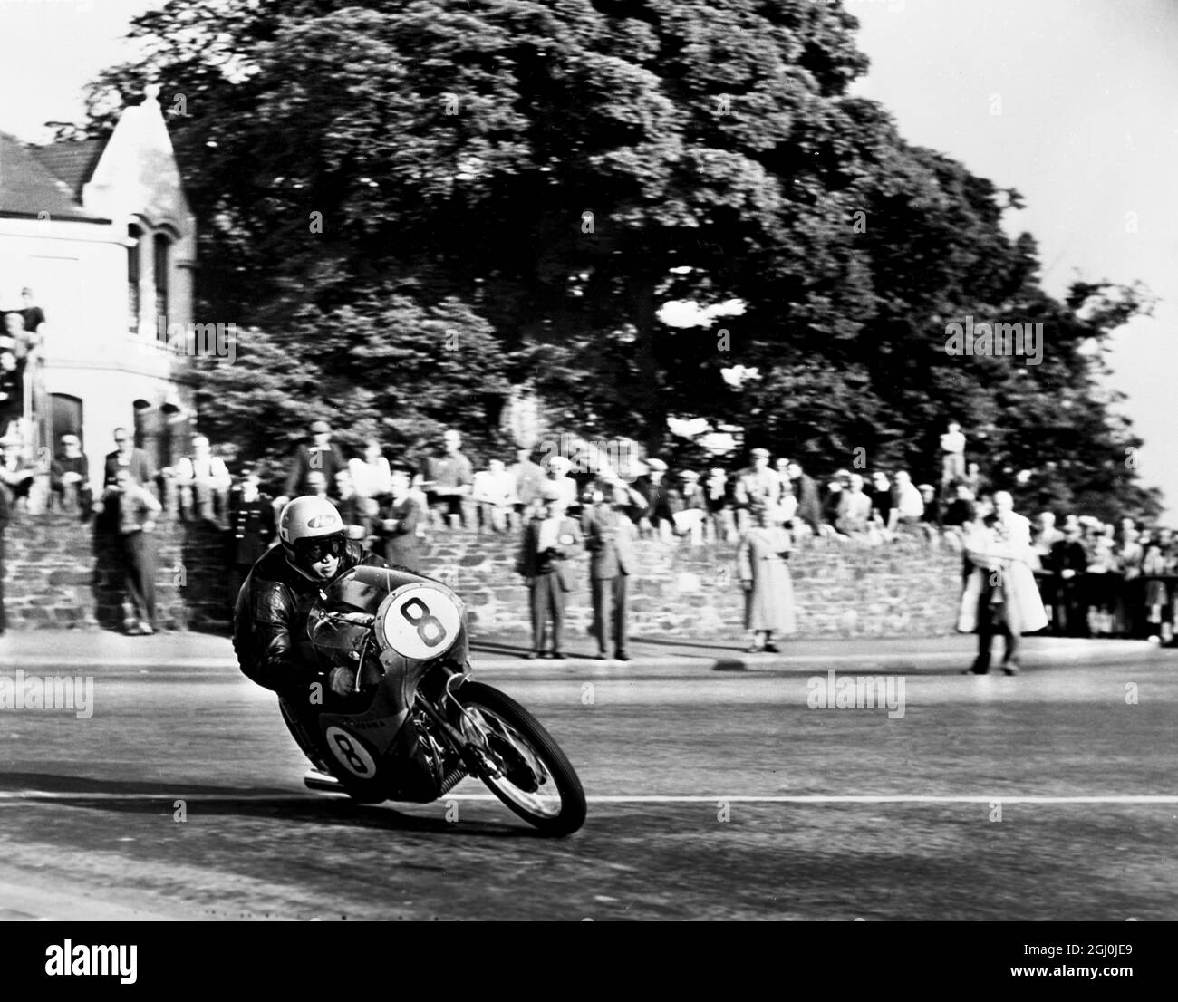 Isle of Man: N Taniguchi of Japan takes the corner at speed, riding a 125cc Japanese honda. He is competing in the forthcoming TT races. 27th May 1959 Stock Photo