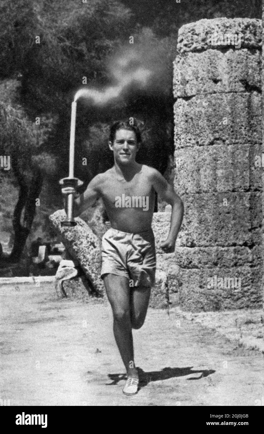 1936 Olympics, Berlin - The young Greek Konstantin Kondyllis carries the Olympia torch-flare over the first part of 3000 km at the Berlin Olympics 1936. Passing the torch from hand to hand. (Der junge Grieche Konstantin Kondyllis trug die Olympiafackel uber den ersten Teil der 3000 km tangen Strecke Olympia-Berlin) ©TopFoto Stock Photo