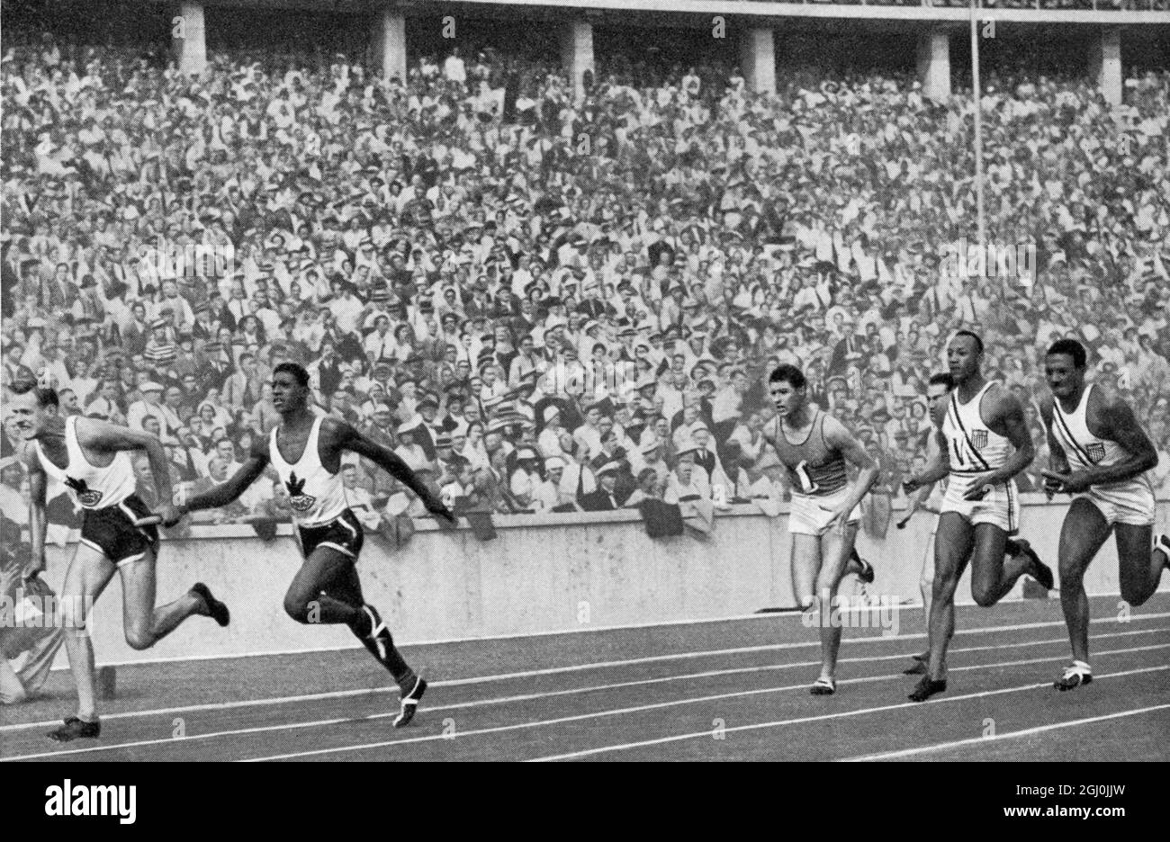 1936 Olympics, Berlin - The first handover of the 4x100-metre relay: Jesse Owens is already in the lead and passes the baton on to Metcalfe. Canada had a curve advantage and here still lies in front. Erster Wechsel der 4x100-metre Staffel: Jesse Owens (vierte Bahn) hat schon Terrain erobert und gibt den Stab an Metcalfe weiter. Canada hatte Kurvenvorgabe und liegt hier noch in Front. ©TopFoto Stock Photo