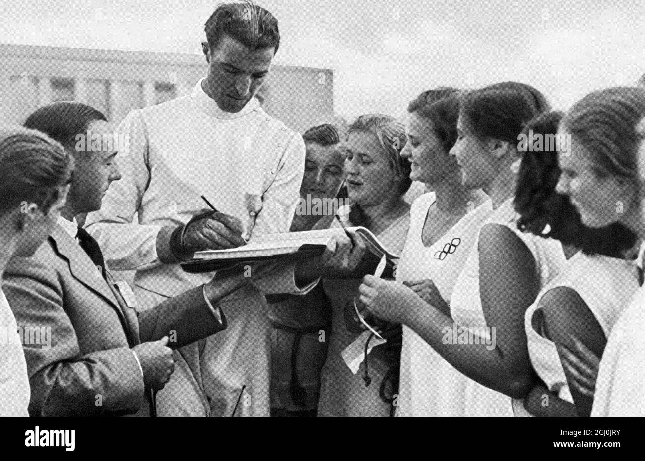 1936 Olympics, Berlin - Giulio Gaudini, the Italian foil and sabre fencing winner gives autographs to the German gymnastics girls. (Giulio Gaudini, der italienische Florett-u. Sabelfechter giht den deutschen Turnerinnen Autogramme.) (©TopFoto Stock Photo