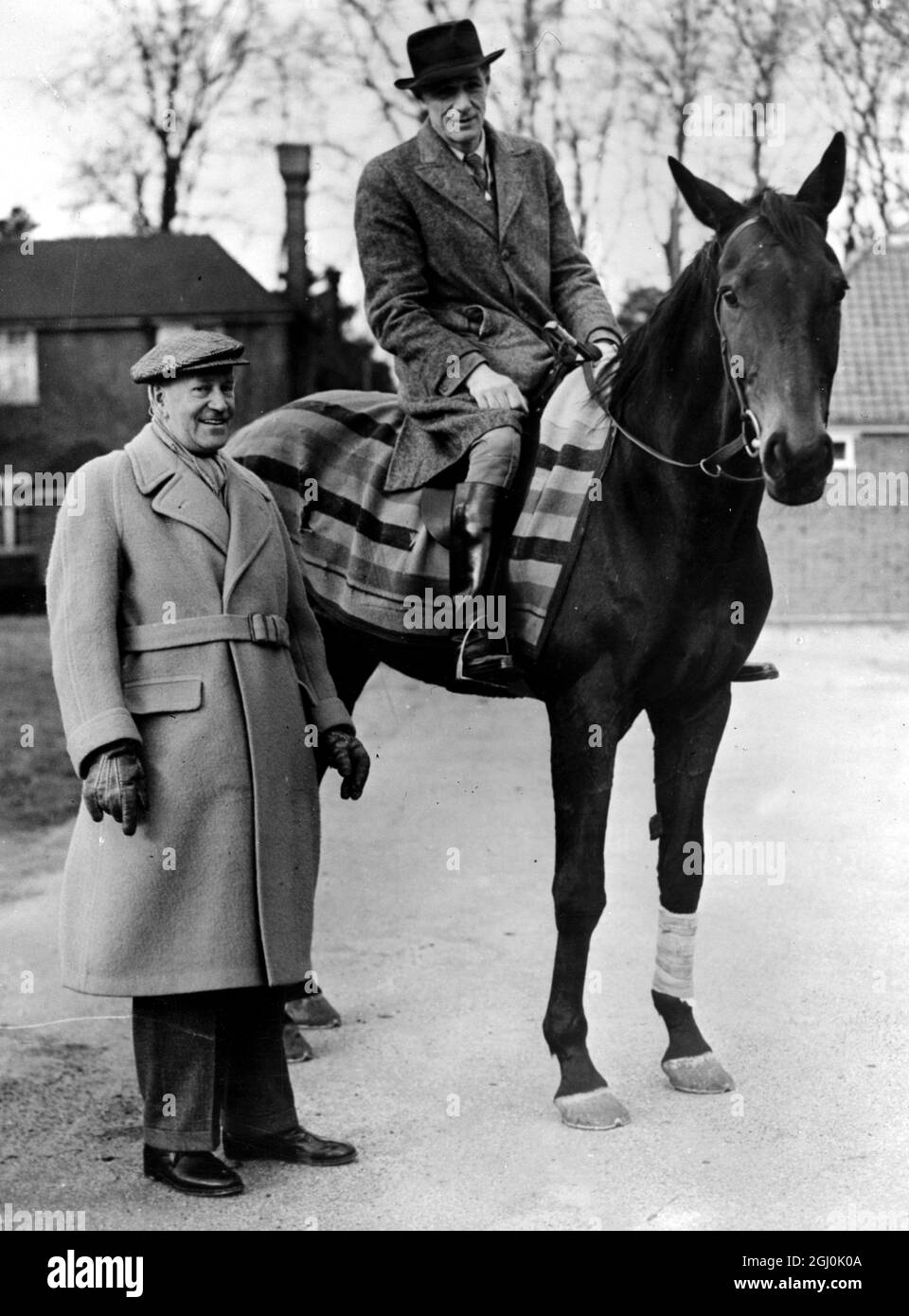 Newmarket: Noel Murless (mounted) a leading Newmarket trainer who is expected to maintain his high reputation this flat race season. With him is James Park, a London evening newspaper racing correspondent 22 March 1954 Stock Photo