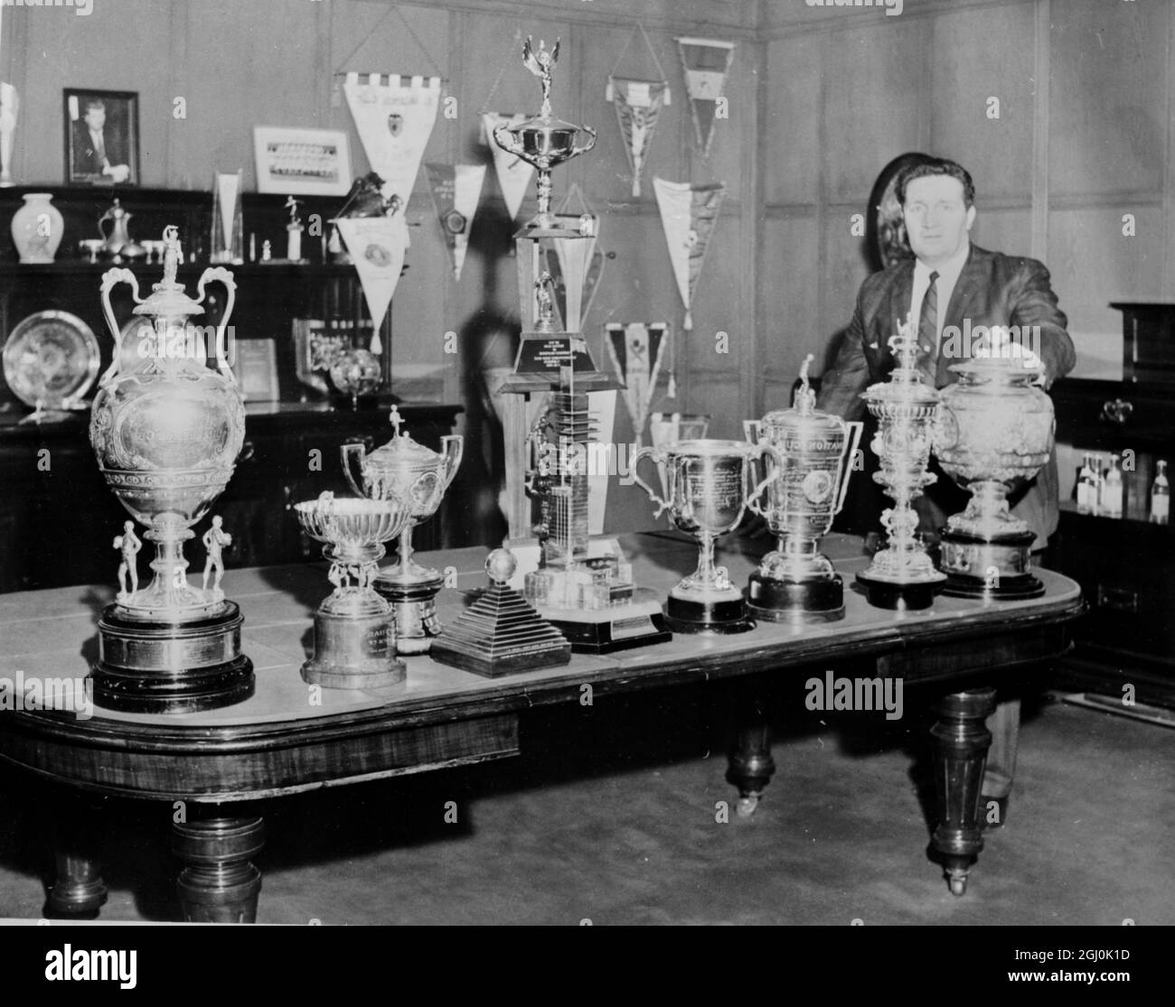 Glasgow: Mr J. Stein, Manager of the Scottish First Division Club and current League Leader, Celtic F.C., poses with some of the trophies won by his men. The Trophies seen left to right are : Ibrox Disaster Trophy; St Mungo Cup; Coronation Cup, Victory in Europe Cup; Empire Cup; Valencia trophy; Glasgow Cup. Tall trophy in the rear is the American Tour Cup. 20 January 1967 Stock Photo