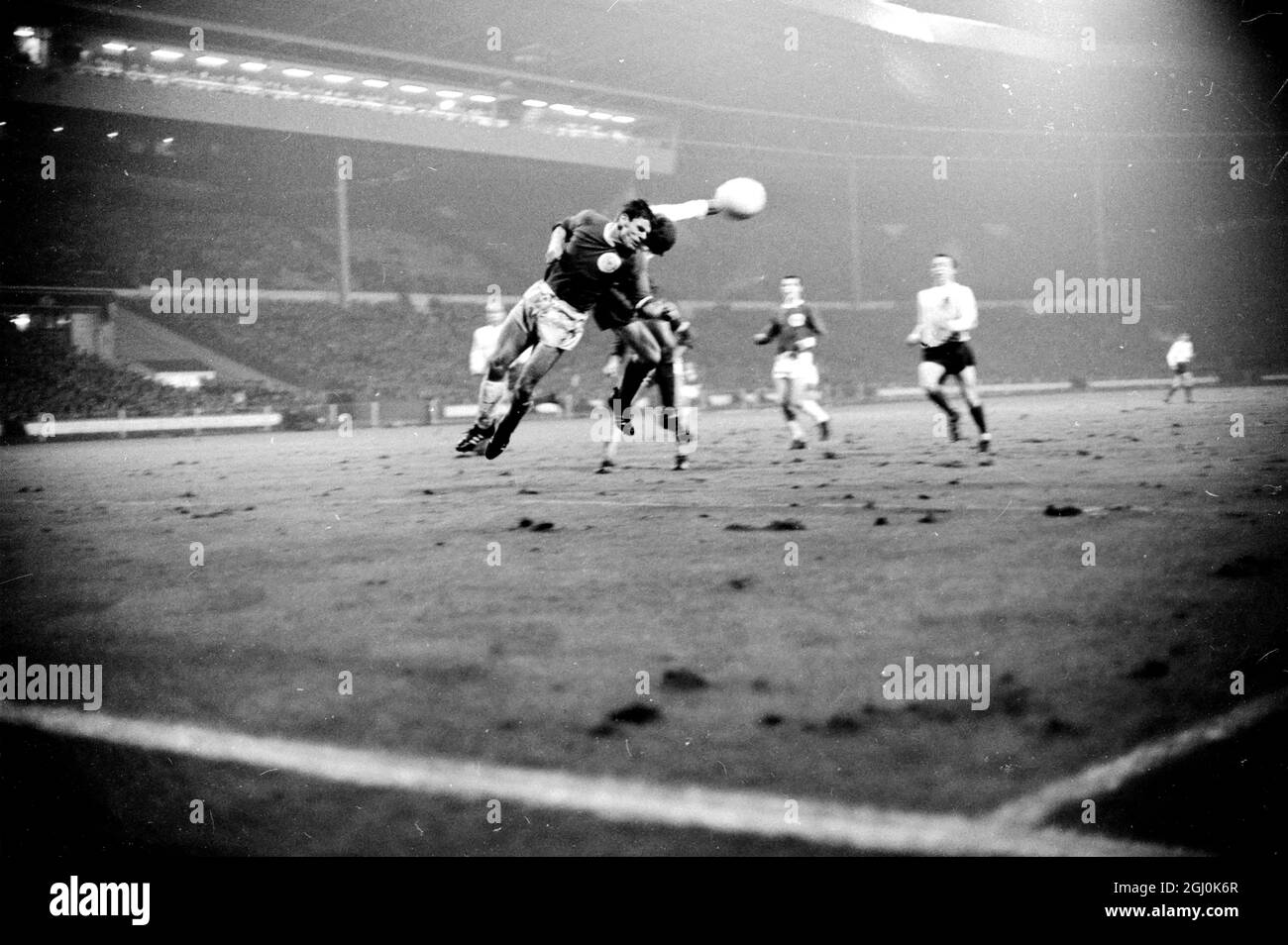 Wembley, Middlesex: England player Roger Hunt (Liverpool), playing at inside-right (white shirt) and West German player Wolfgang Weber (F.C. Cologne), playing centre-half in tonights football in Association International Match at the Empire Pool between Germany and England , are in acton during the match. The match was played in heavy rain, in soggy conditions; was watched by a crowd estimated at 50,000. Final score was 1 -0 for England, the goal being scored by centre-forward stiles int 41st minute. 23 February 1966 23 February 1966 Stock Photo