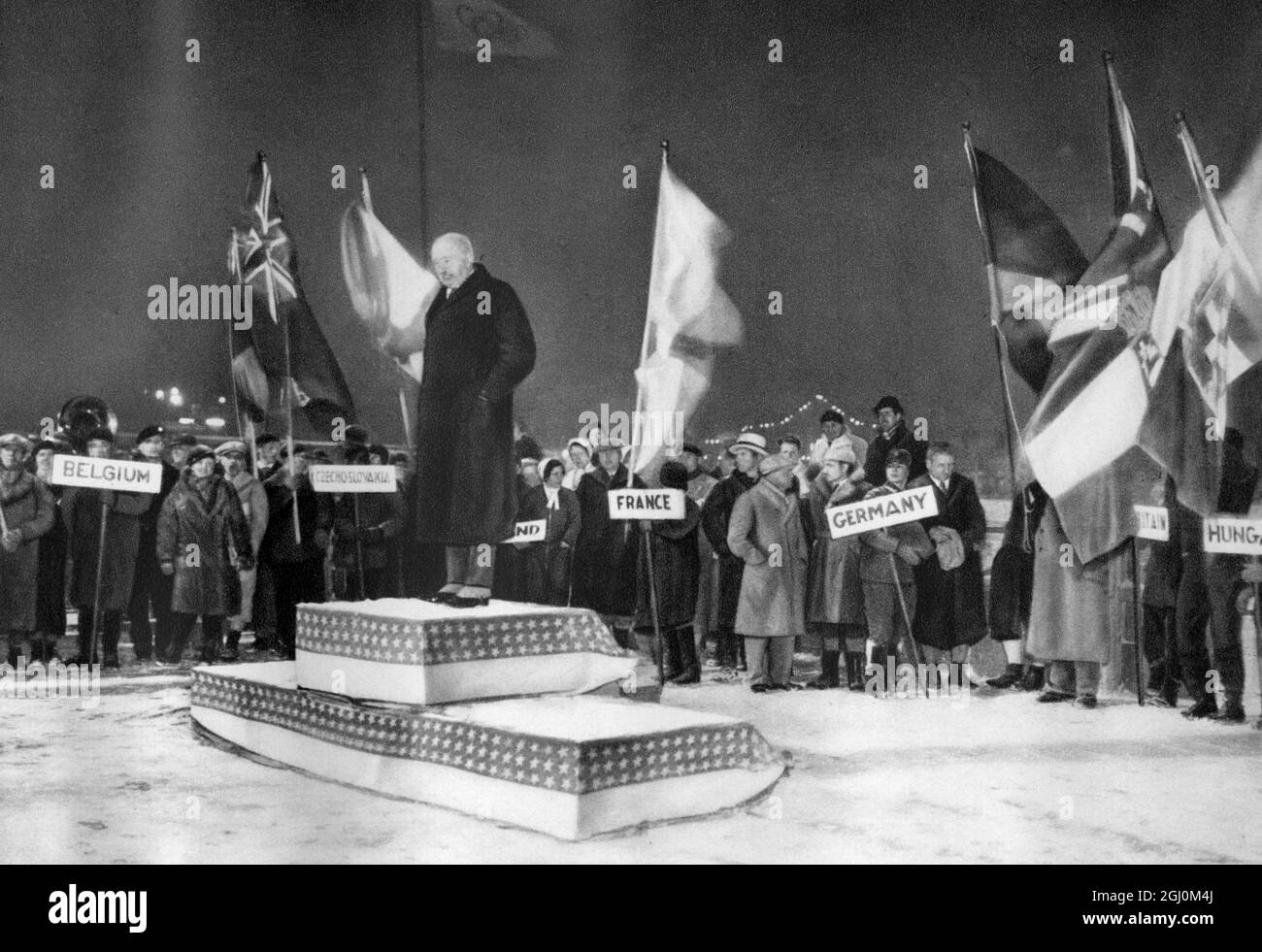 Lake Placid, 15 February 1932. IOC president Henri de BAILLET-LATOUR, declaring closed the II Olympic Winter Games, surrounded by the nations' flag bearers Stock Photo