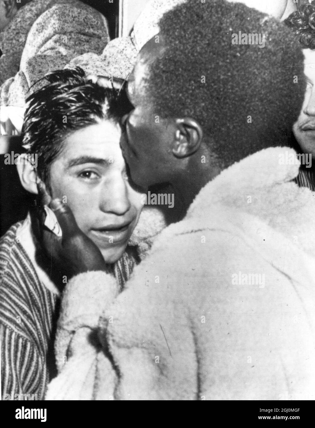 Wrigley Field , Los Angeles . Hogan ' Kid ' Bassey of Nigeria the World Featherweight Champion was restrained by referee after the former had floored Ricardo ' Little Bird ' of Liverpool in the third round . The count ended with only seconds of the round to go . Bassey planting a kiss on forehead of Ricardo 3 April 1958 Stock Photo