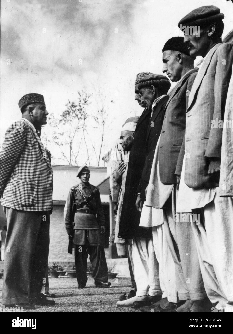 Life in a remote area of Northern Pakistan - where important Archaeological finds have been made . The Wali Sahib present Ruler of Swat in western style sports coat and traditional lamb's wool Pakistani cap interviews some of his subjects in front of Government Offices in capital City of Saidu Shariff . 1958 Stock Photo