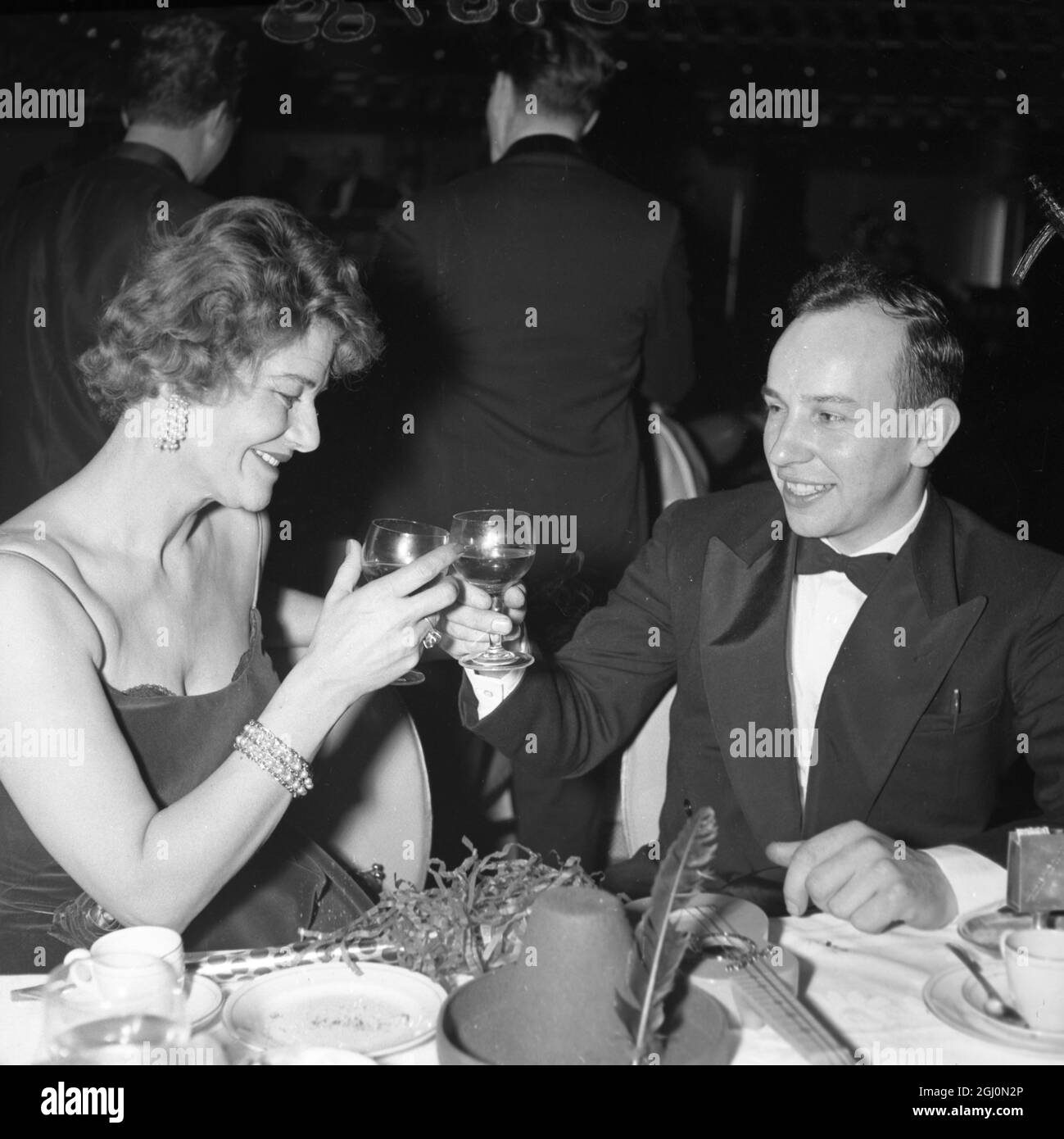 John Surtees drinks a toast with a friend as the old year passes at the ''Talk of the Town'' nightspot 1st January 1960 Stock Photo