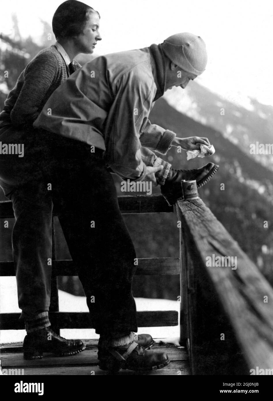 Grease is an important item in the mountaineer's equipment , these climbers are greasing their boots in preparation for the day's climb Stock Photo