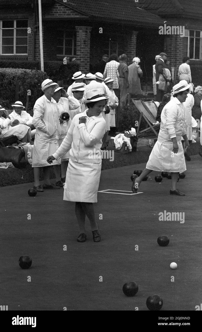A woman bowler looks on while the umpire measures the distance between the wood and the white ball , at the Amateur National Championships of the English Women's Bowling Association at Wimbledon Park , London , England . 25 August 1969 Stock Photo