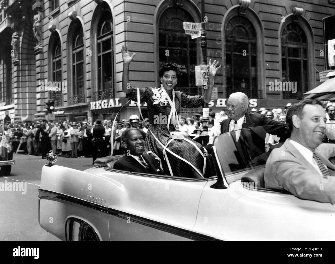 Miss Althea Gibson , who has just become Ladies Singles lawn tennis champion at Wimbledon , waves from an open car during the parade up Broadway , which was New York 's official tribute to her return . 11th July 1957 Stock Photo