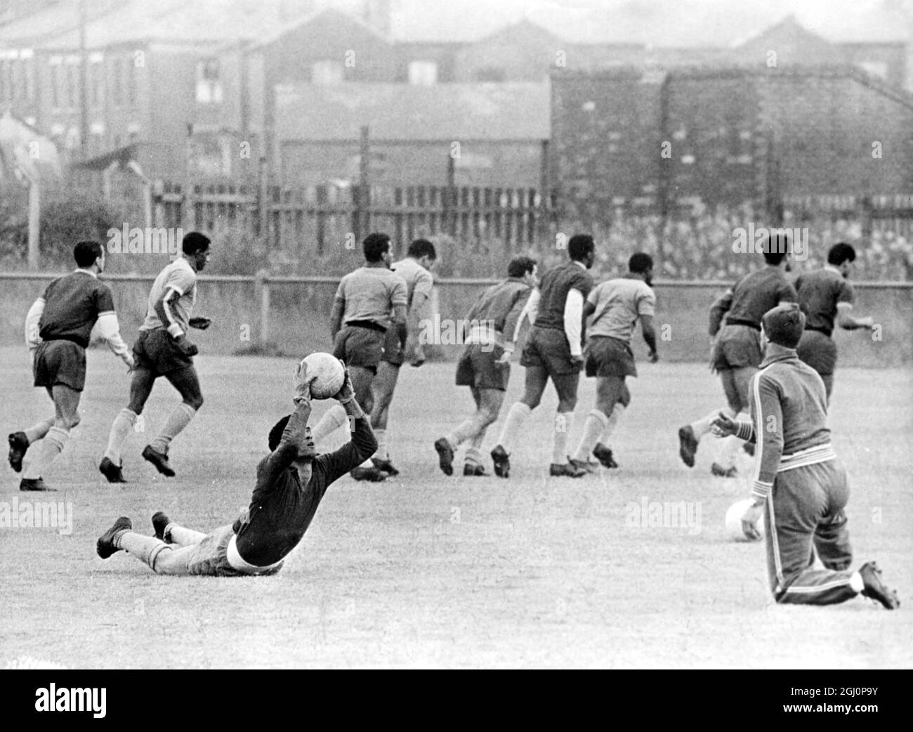 Brazilians training at Bolton . Bolton , Lancs , England : Paulo Amaral , trainer of the Brazilian footballers , seen throwing the ball to Manga , one of the two goal - keepers , as other players train in the background . Brazil meet Hungary at Goodison Park , Liverpool tonight . 15 July 1966 Stock Photo
