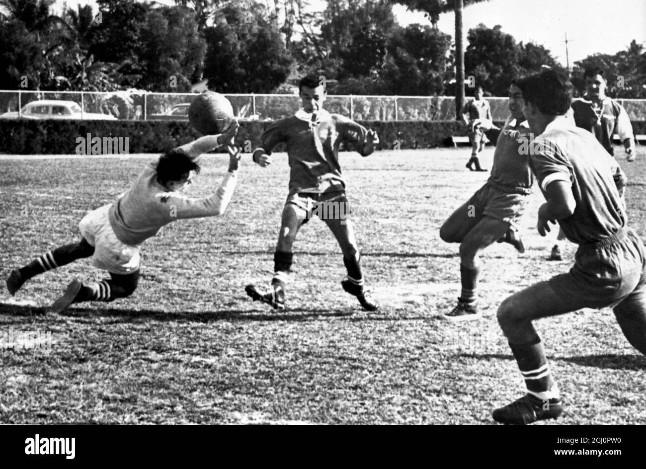 Goalkeeper Ernest Bankuti , of Magyar AC , a Hungarian soccer team , is seen saving a goal when his team played and defeated Coral Gables team at Curtis Park , Miami , USA. Three Coral Gables players are seen close at hand to try for the goal . 21 January 1958 Stock Photo