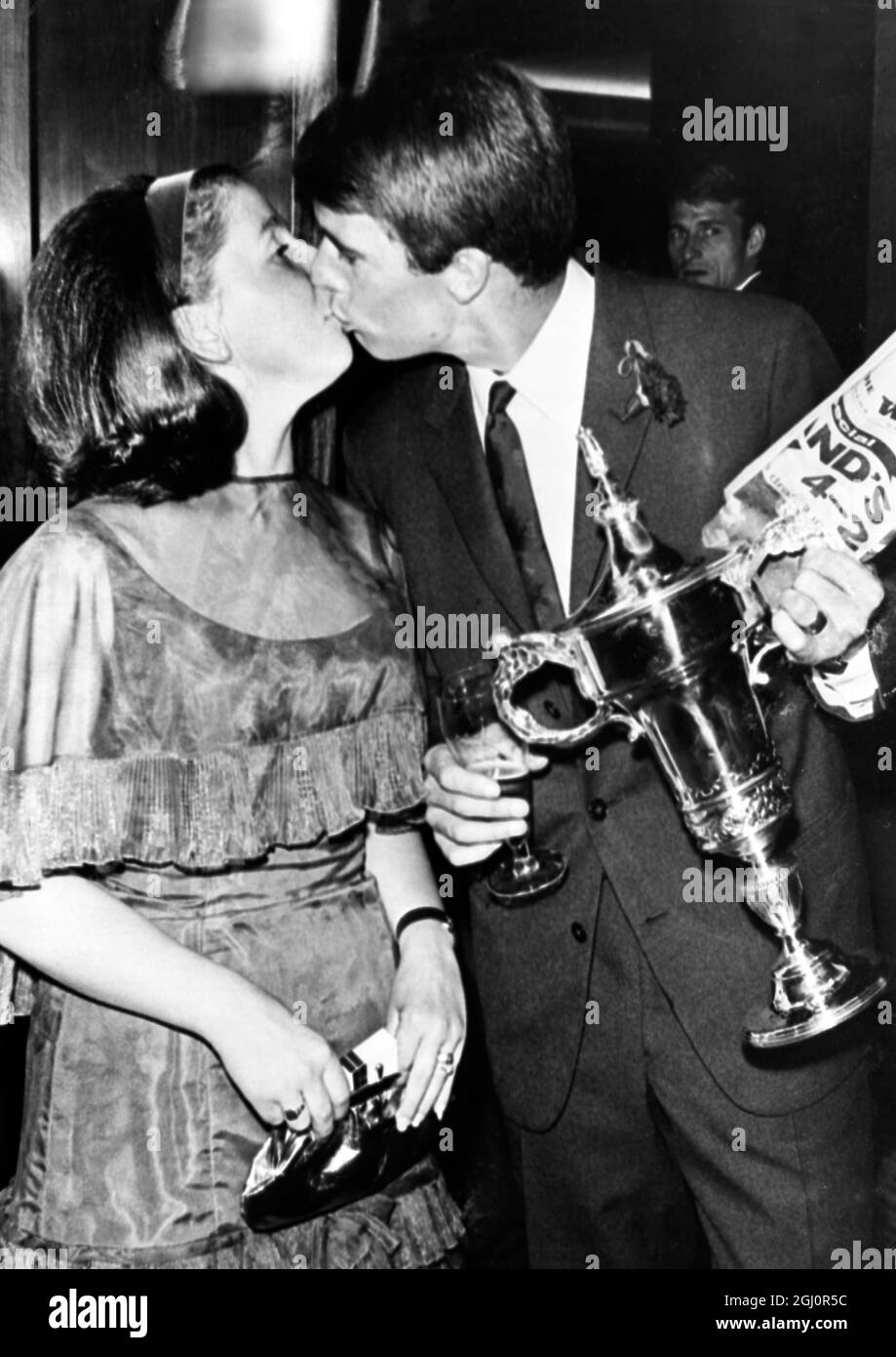 England's Hero. Geoff HurstHolding the trophy presented to him by a National Newspaper as the Best Player in yesterday's World Cup Final at Wembley Stadium, England's Geoff Hurst, who scored three of his county's four goals against West Germany, kisses his wife during last night's reception given for the victorious England team by the Government at a Kensington Hotel. England defeated West Germany by four goals to two after extra time to win the covested world trophy. 31 July 1966 Stock Photo