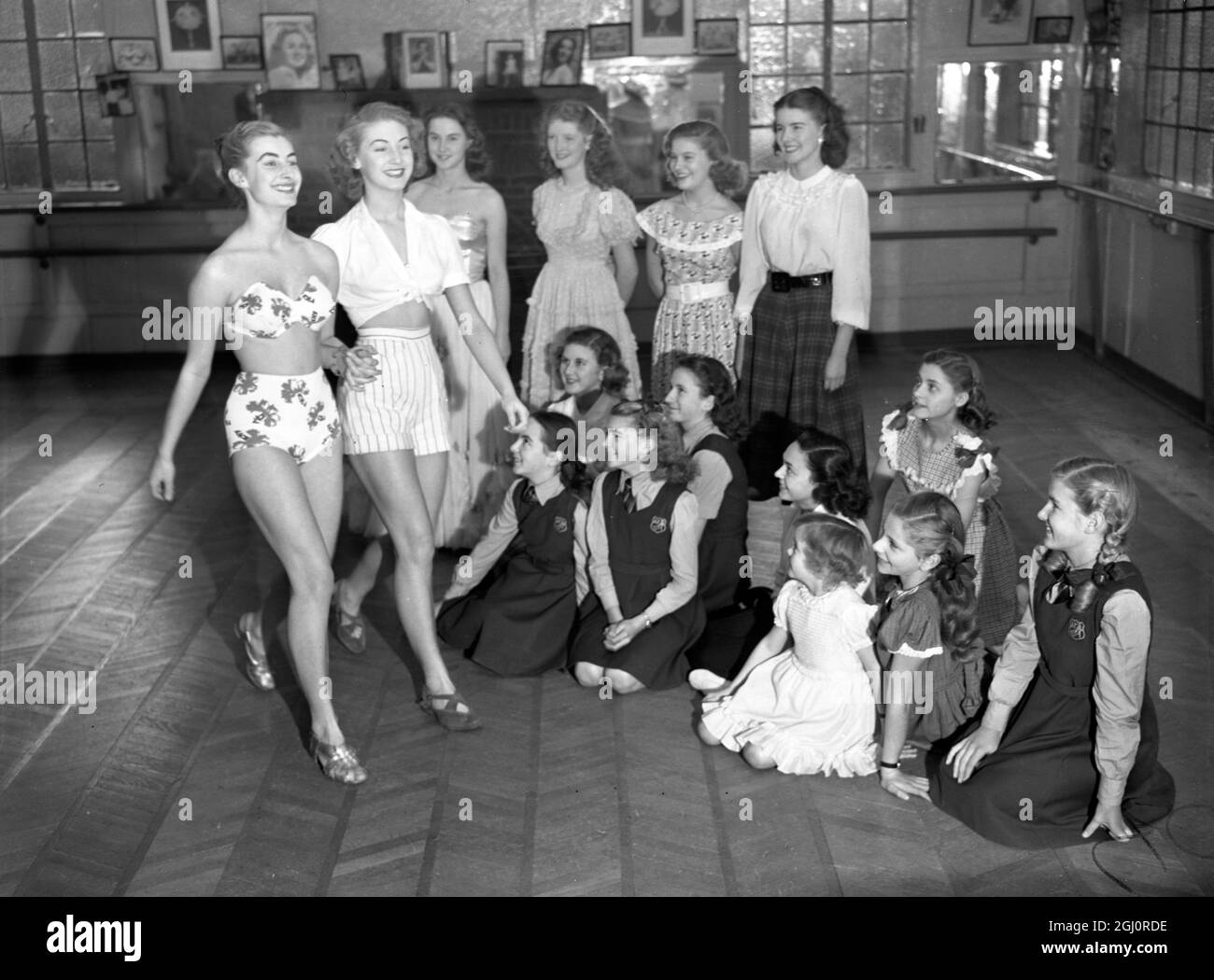 Model schoolgirl to star in schoolgirls fashion show at the Dorchester Hotel The perfect schoolgirl , seventeen year old Yvonne Marsh , will be the star of a display of children's and teenage fashions at the Dorchester on 6 November 1950. She will show evening gowns , sportswear and day clothes with nineteen other girls , all trained to walk with the assured air of mannequins . Left to right : Jean Marsh , aged 16 , with her sister Yvonne Marsh , age 17 , the perfect schoolgirl , show off beachwear at the Aida Foster School watched by other girls who will also be in the show Stock Photo