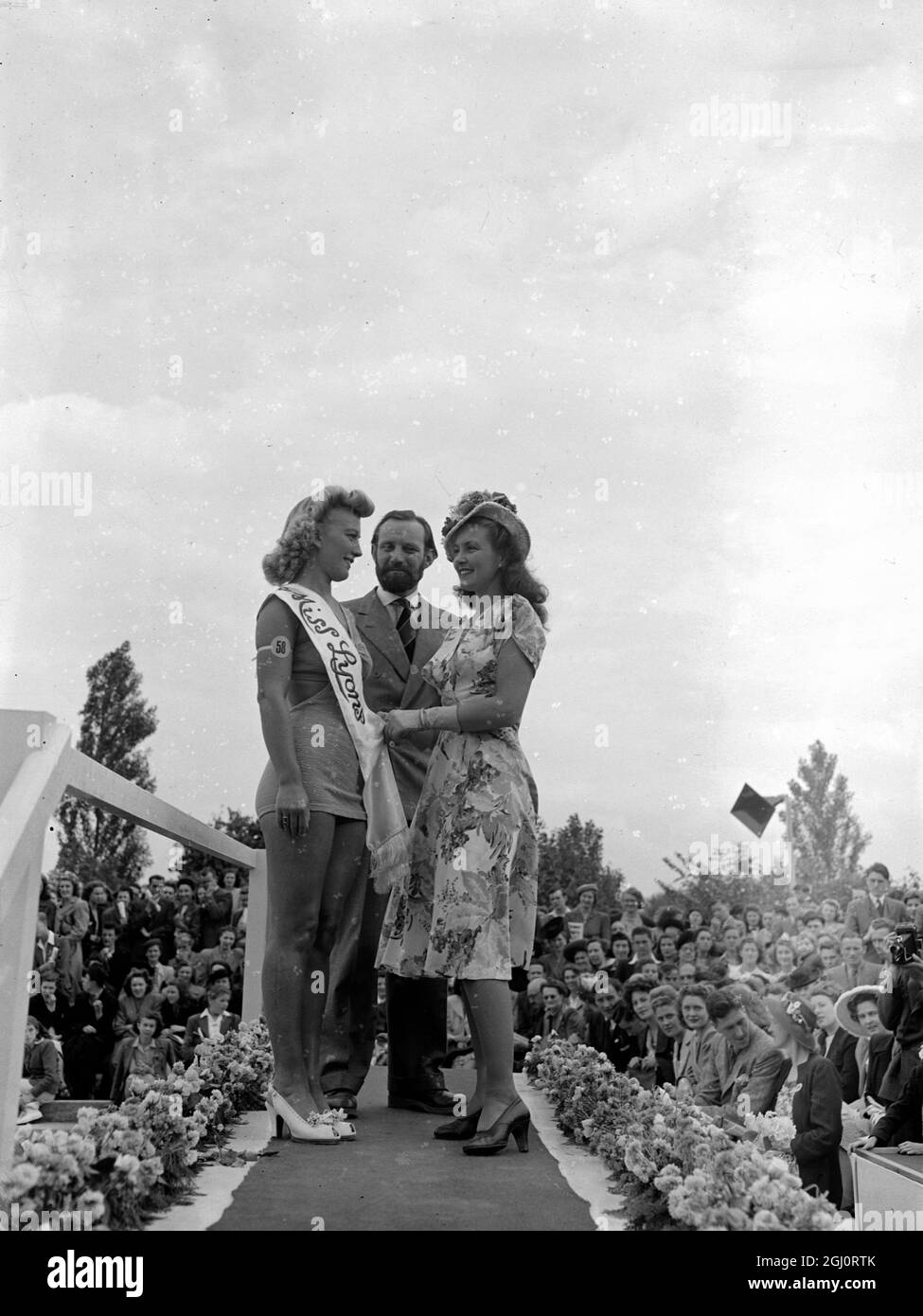 PATRICIA ROC AND TEN BEAUTY QUEENS ATTENDED LYONS CLUB ANNUAL SPORTS Ten Beauty Queens from London Boroughs attended the Lyons Club annual sports and carnival at Sudbury to-day. They served as models for Patricia Roc and Trevor Howard, who have to decide which ''Nippy'' shall be ''Miss Lyons'' of 1947. The new Lyons Queen will make a ''state drive'' round the sports arena this evening. Ten hours of carnival are provided in addition to boxing, diving and swimming displays. The evening closes with a fireworks display. Photo Shows: Patricia Roc and Trevor Howard with the winner of this year's ''M Stock Photo