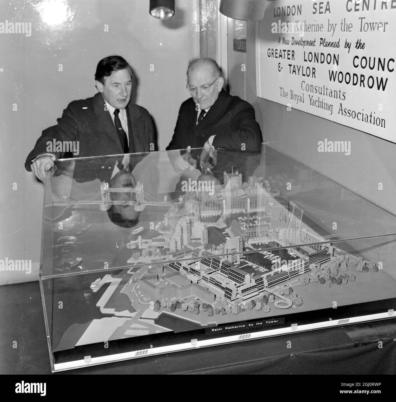 London: Sir Francis Chichester (right), Britain's epic lone round-the-world yachtman, view a model of the St Katharine Docks development scheme, planned by the Greater London Council, when he visited the international Boat Show at Earls Court, London today. Site for the scheme is next to London's Historic Tower of London. The proposed scheme will incorporate London's only yacht basin, capable of berthing some 250 craft. 8 January1970 Stock Photo