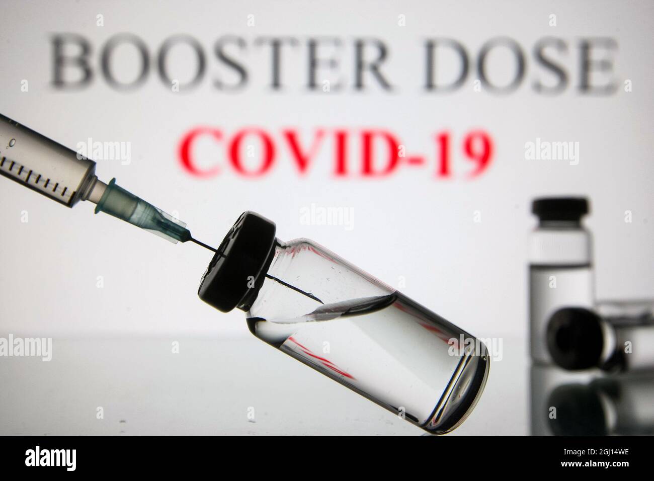Ukraine. 07th Sep, 2021. In this photo illustration a medical syringe and vials are seen displayed in front of the Booster dose and Covid-19 logo. Credit: SOPA Images Limited/Alamy Live News Stock Photo