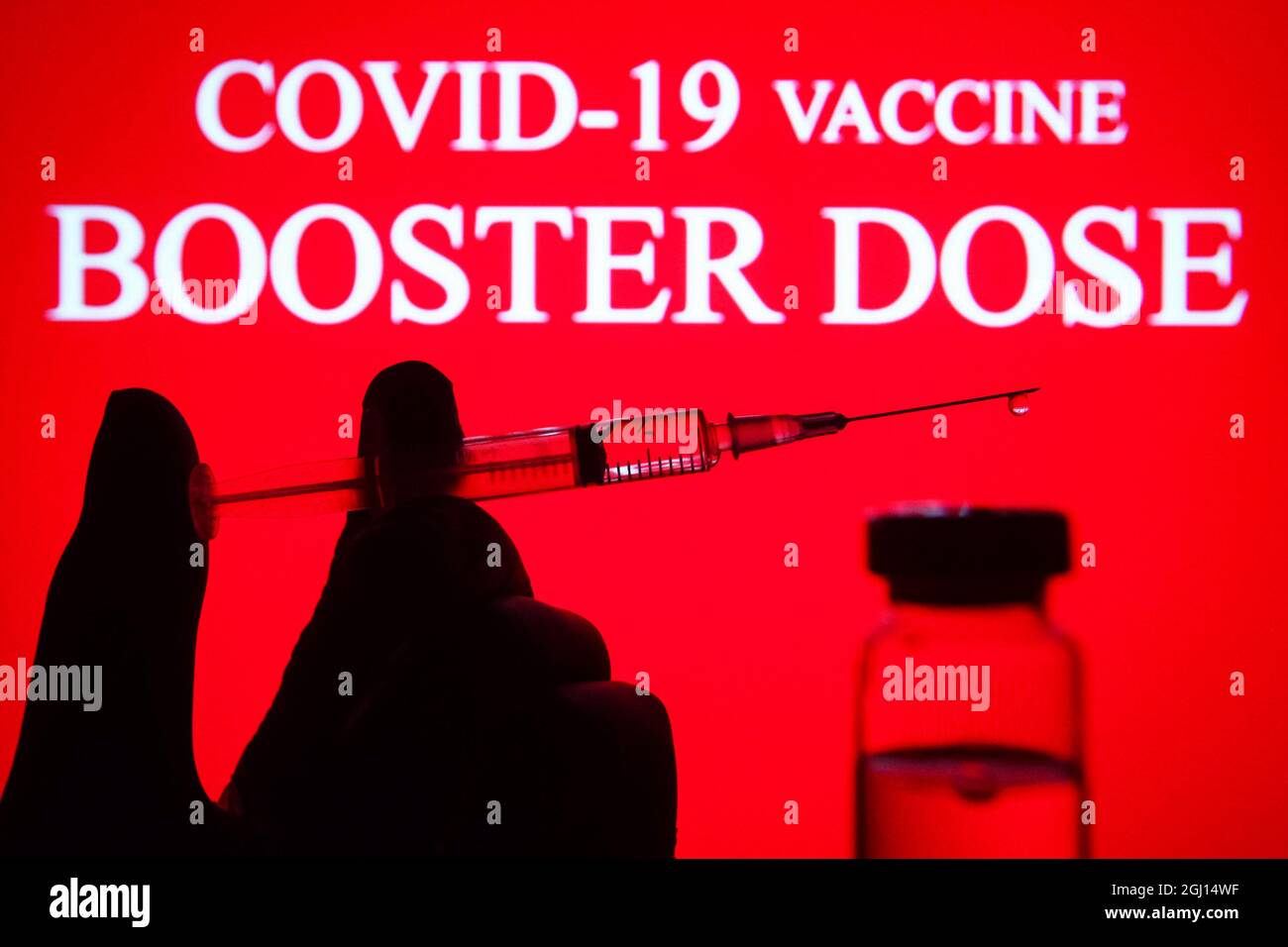 Ukraine. 07th Sep, 2021. In this photo illustration a medical syringe and a vial are seen displayed in front of the Covid-19 vaccine booster dose logo. Credit: SOPA Images Limited/Alamy Live News Stock Photo