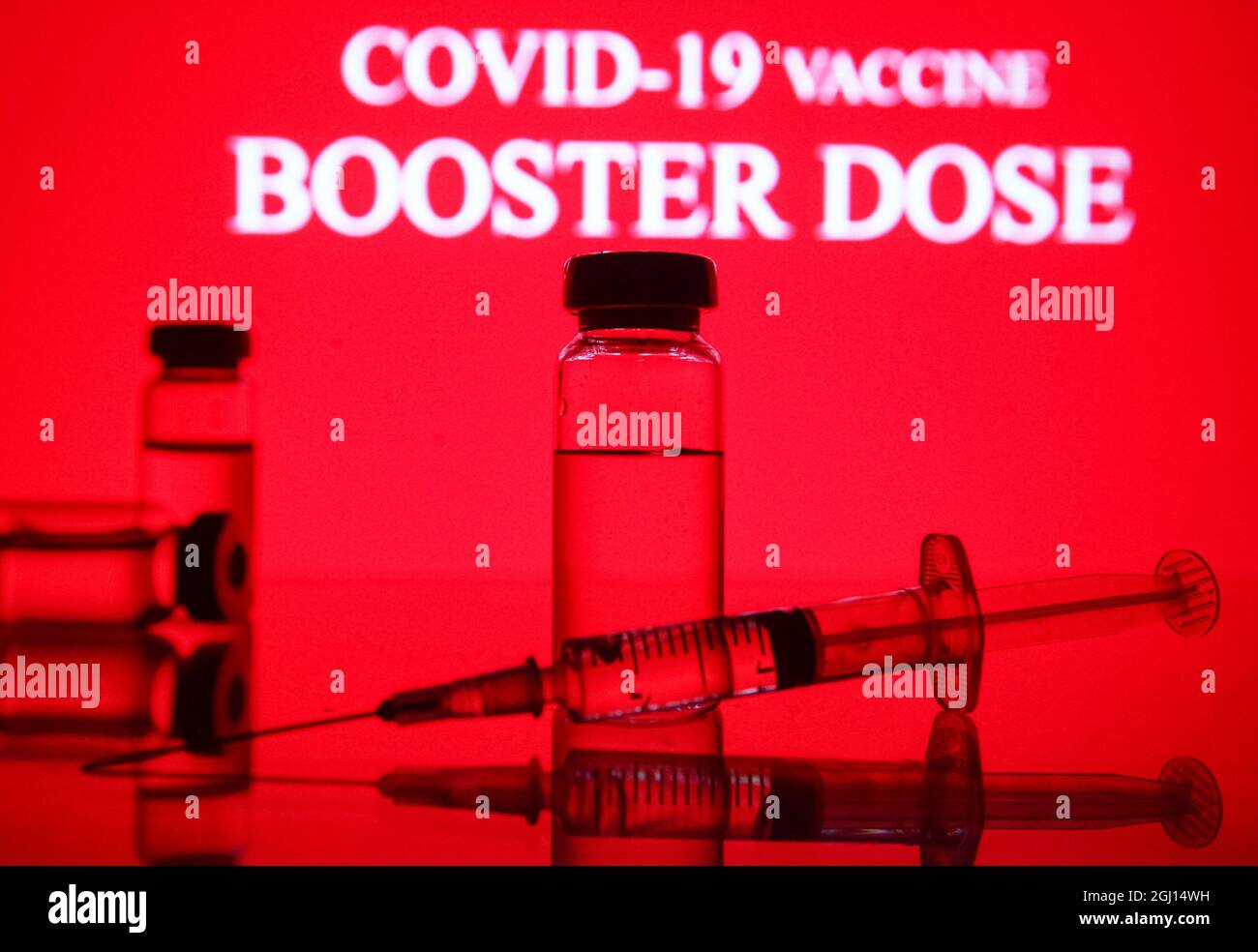 Ukraine. 07th Sep, 2021. In this photo illustration a medical syringe and vials are seen displayed in front of the Covid-19 vaccine booster dose logo. Credit: SOPA Images Limited/Alamy Live News Stock Photo