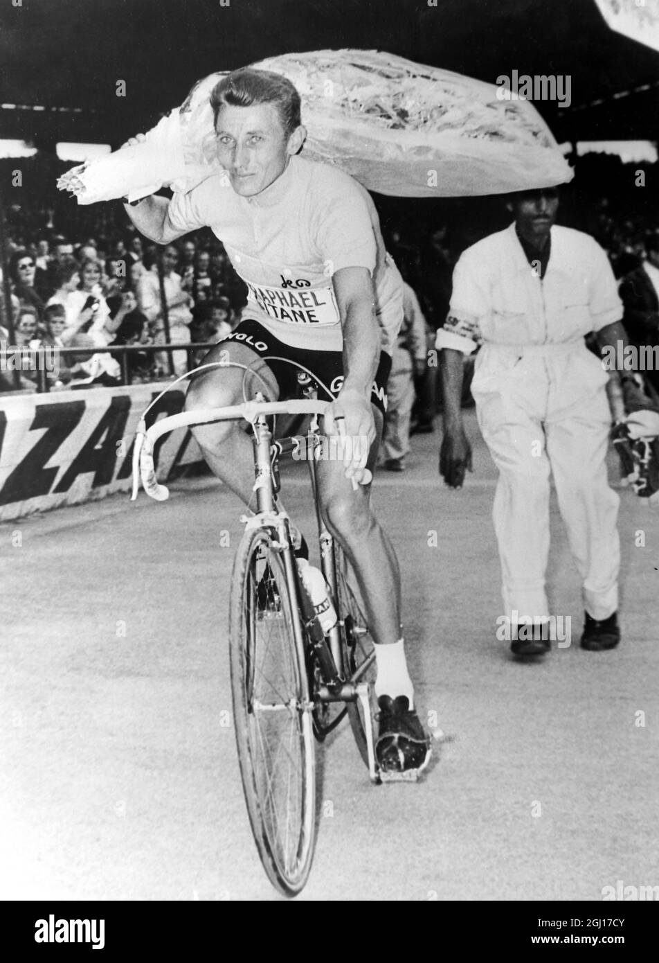 15 JULY 1963 JACQUES ANQUETIL RIDES HIS BICYCLE WITH A BOUQUET OF FLOWERS AFTER WINNING THE TOUR DE FRANCE, PARIS, FRANCE. Stock Photo
